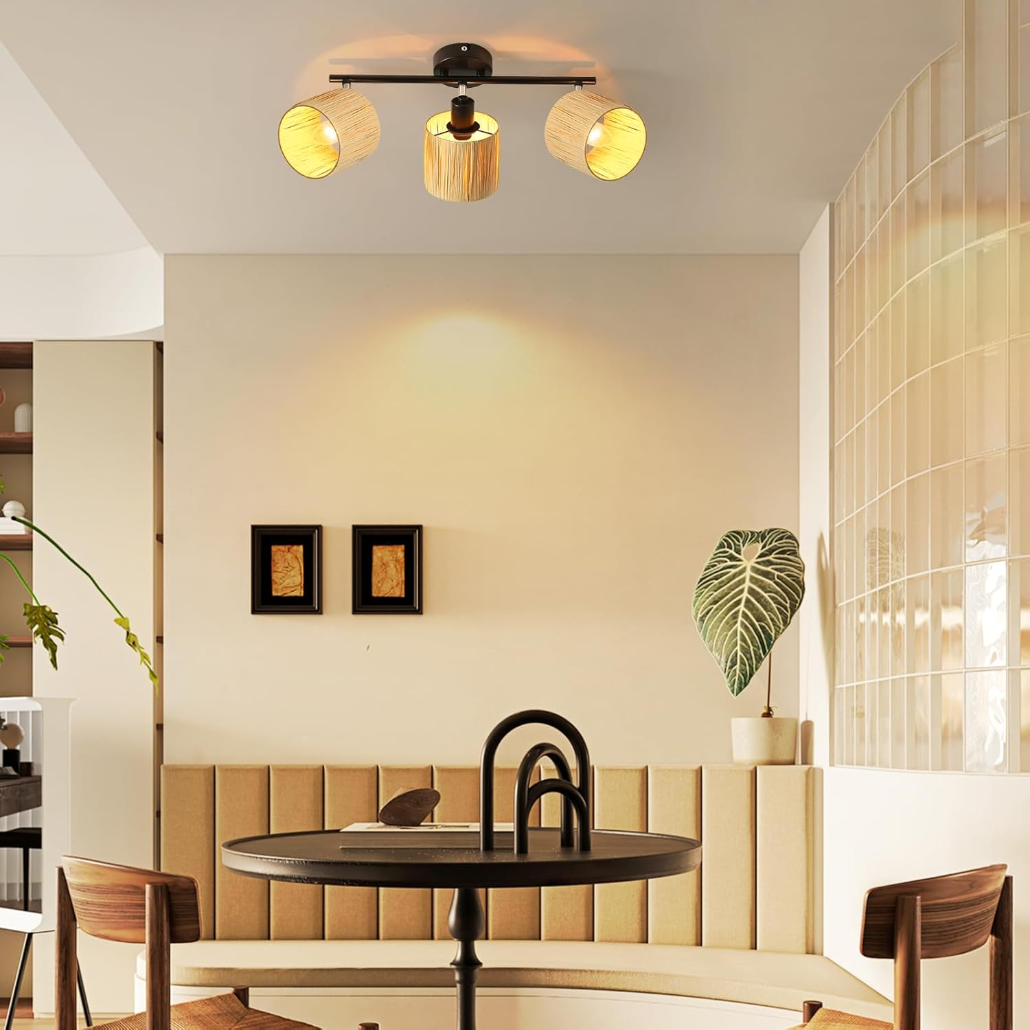 Ustawienie kuchni z trzema wiszącymi lampami, dwoma oprawionymi zdjęciami i stołem z krzesłami.