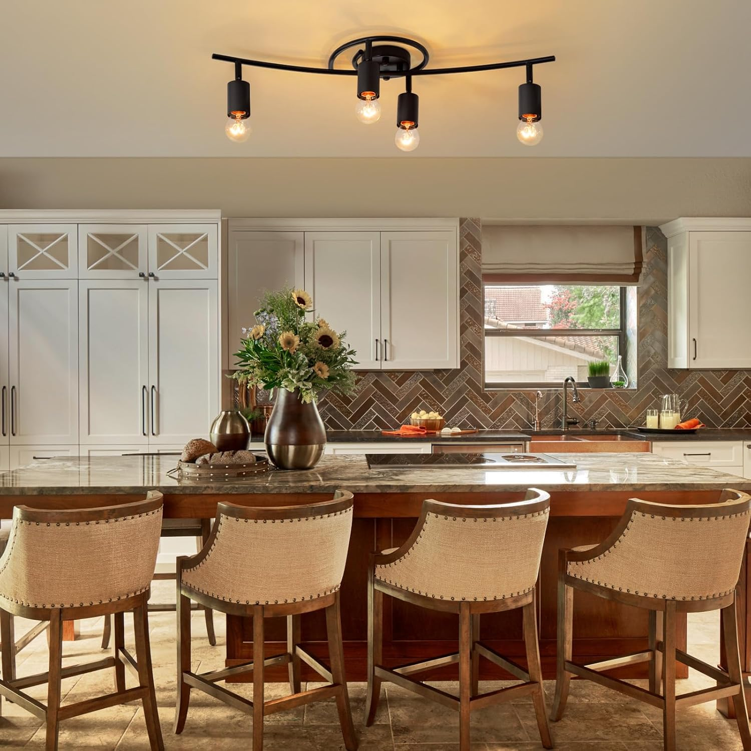 Kuchnia z oświetleniem szynowym. Jest blat ze stołkami i okno.