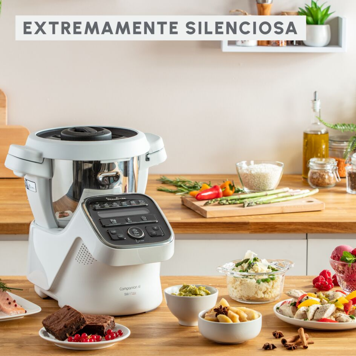 Un procesador de alimentos con varios platos en una mesa de madera, con texto arriba.