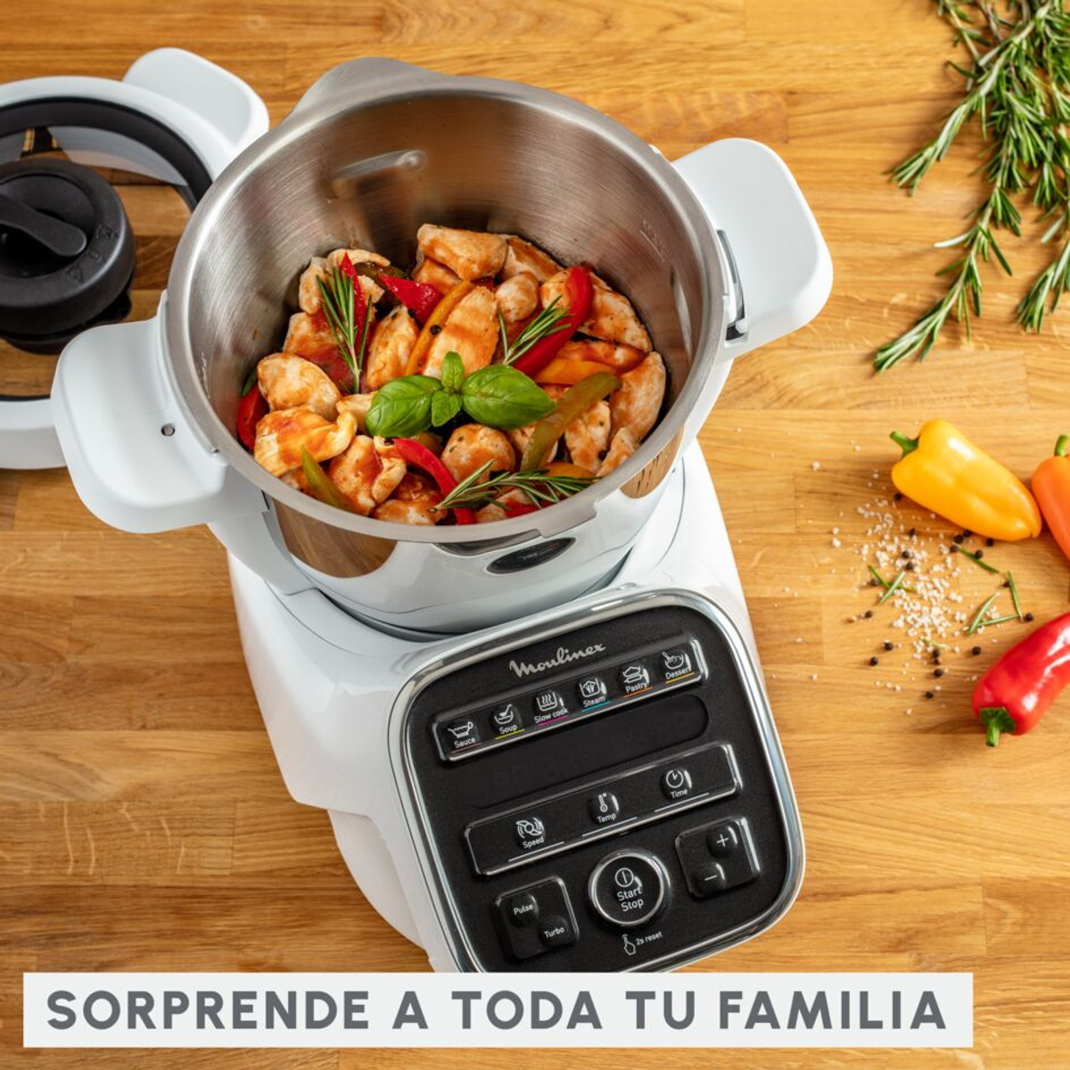Un electrodoméstico de cocina Moulinex blanco con comida dentro, rodeado de ingredientes y un panel de control.