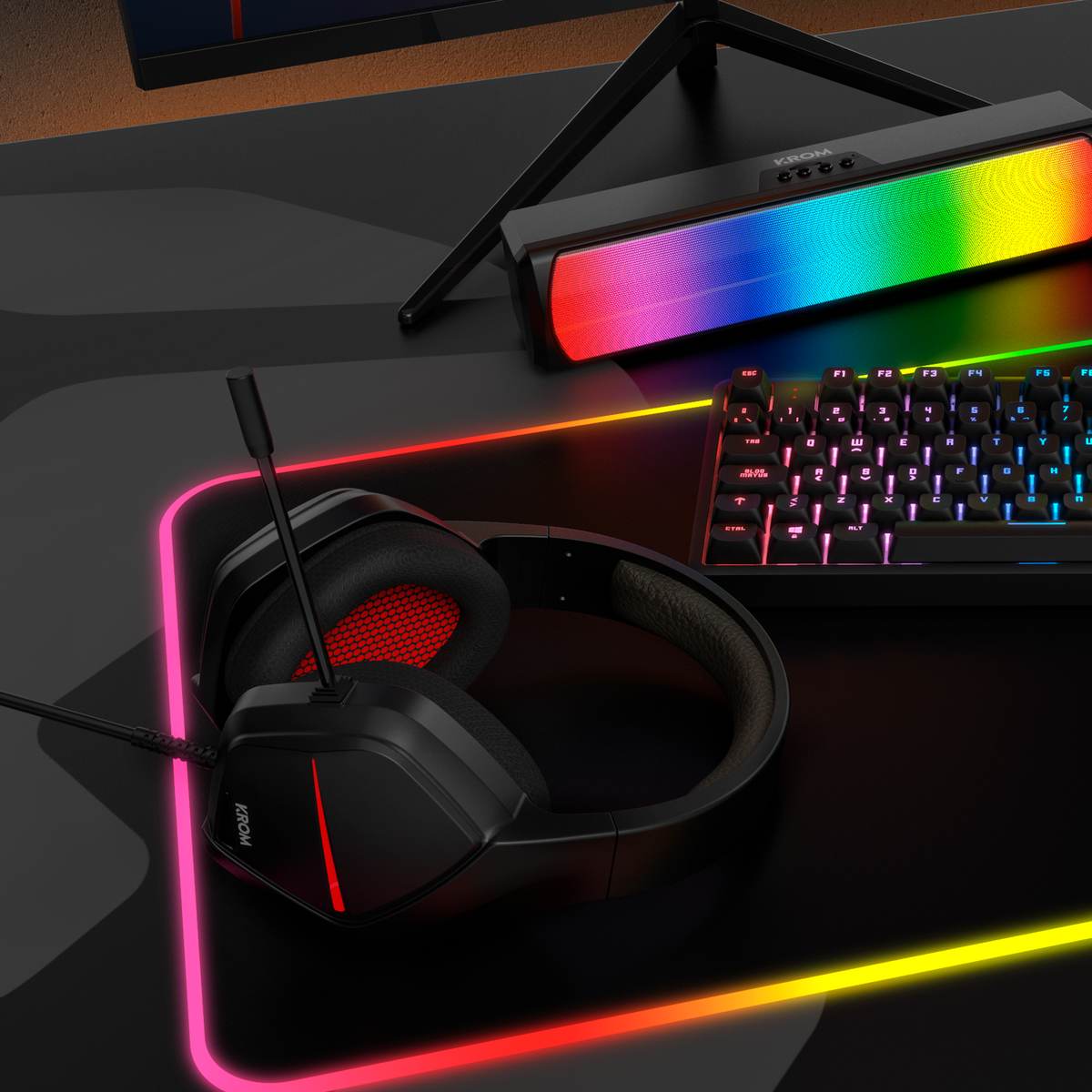 Konfiguracja do gier ze słuchawkami, klawiaturą i głośnikiem z tęczowymi światłami LED.