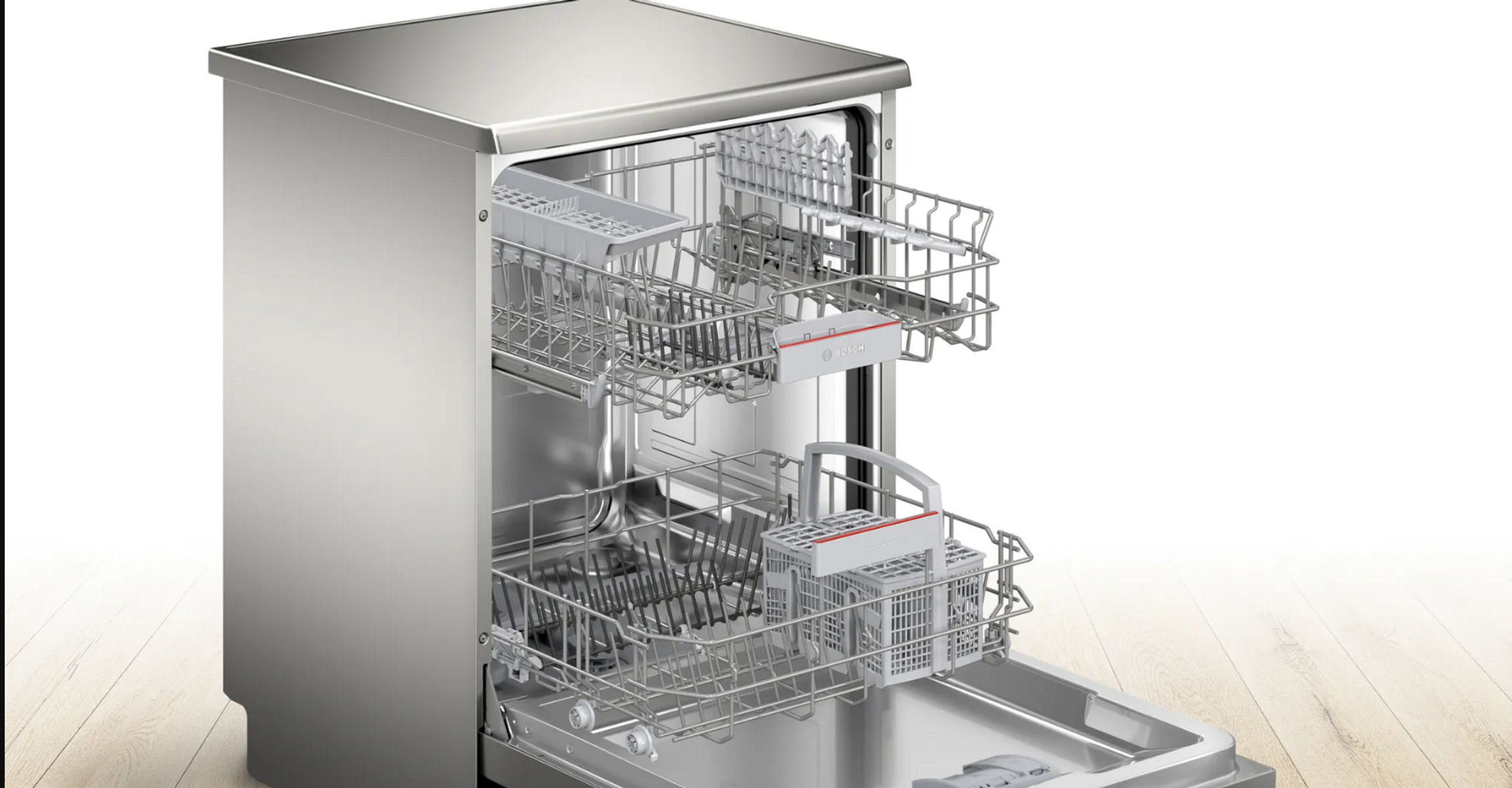 Zbliżenie na otwarte wnętrze zmywarki ze stali nierdzewnej z koszami.