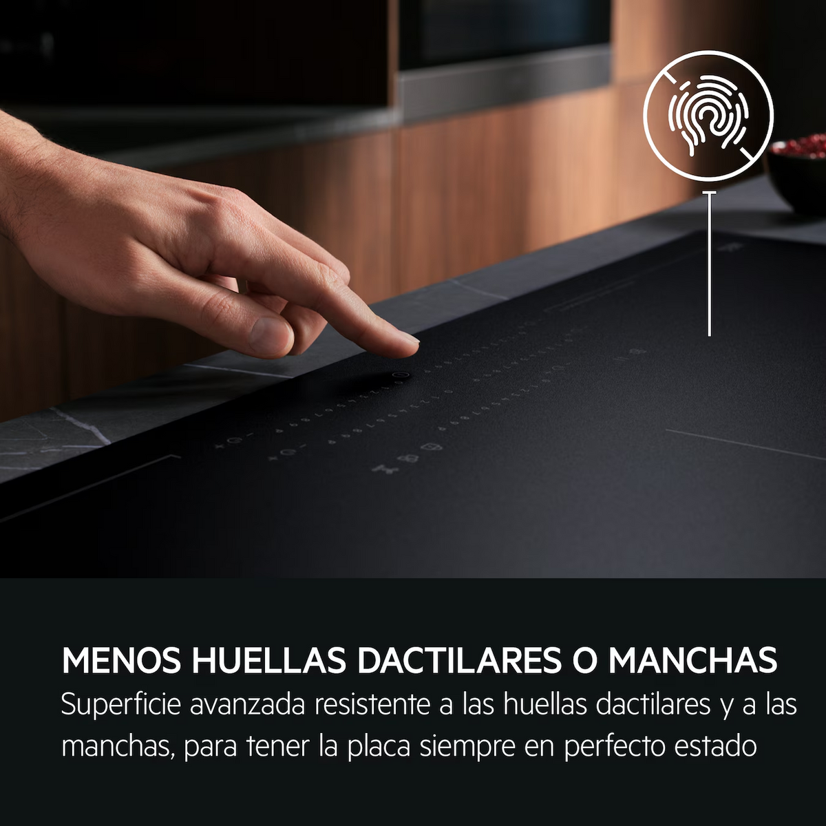 Zbliżenie czarnej płyty grzewczej z palcem dotykającym panelu sterowania. Tekst: 'MNIEJ ODCISKÓW PALCÓW LUB PLAM'.
