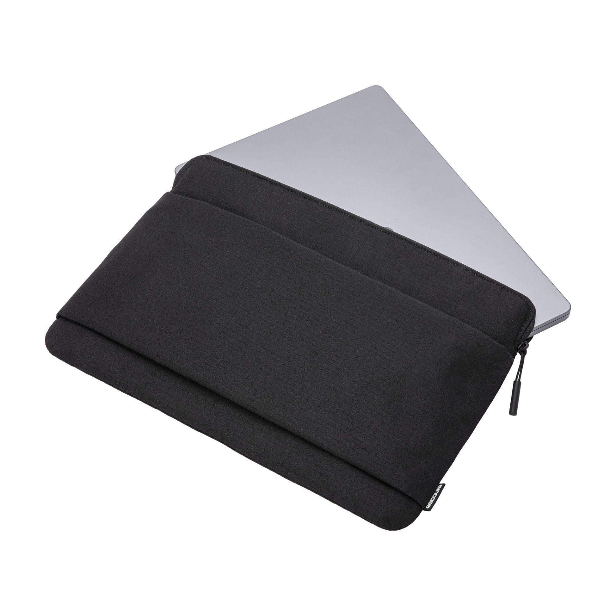 Custodia nera per laptop. Un laptop grigio è parzialmente inserito. La custodia ha una cerniera e il logo Incase.