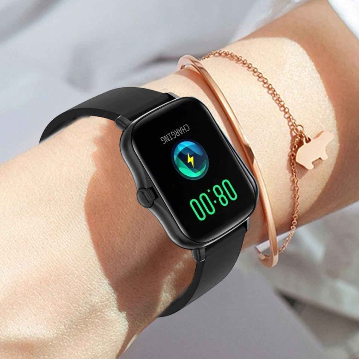 Schwarze Smartwatch am Handgelenk zeigt Ladesymbol und Uhrzeit 08:00 Uhr. Ein goldenes Armband.