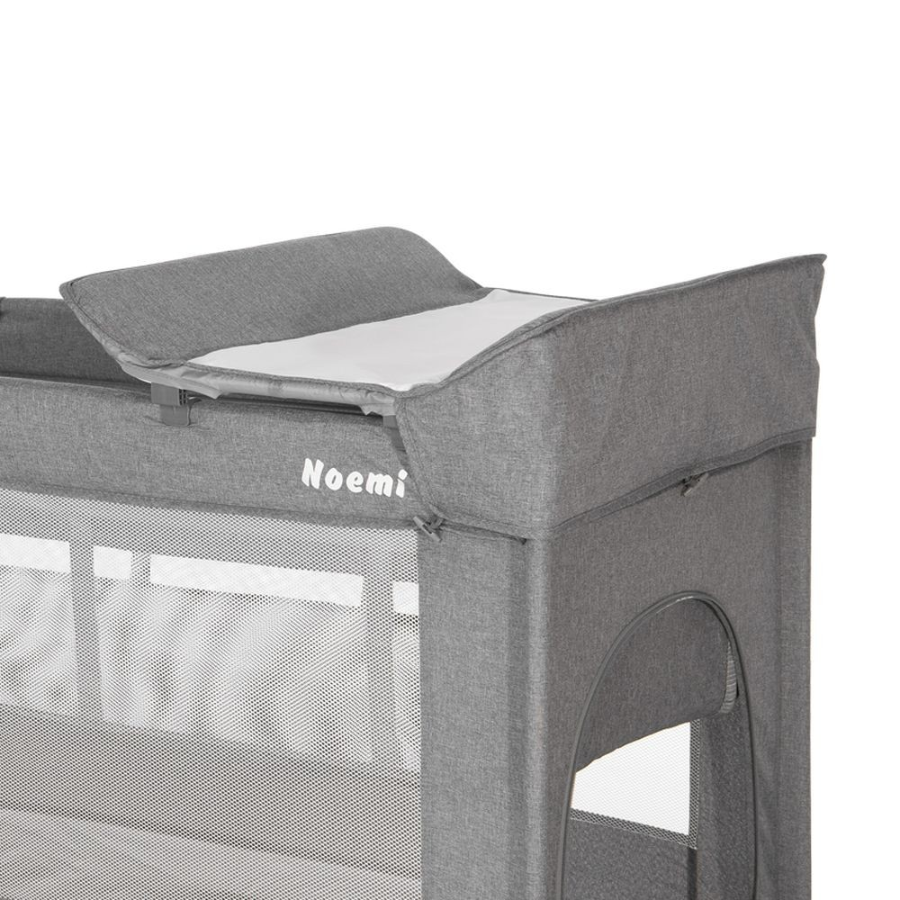 Graues Babybett mit Wickelauflage oben. Das Bett hat eine Netzseite.