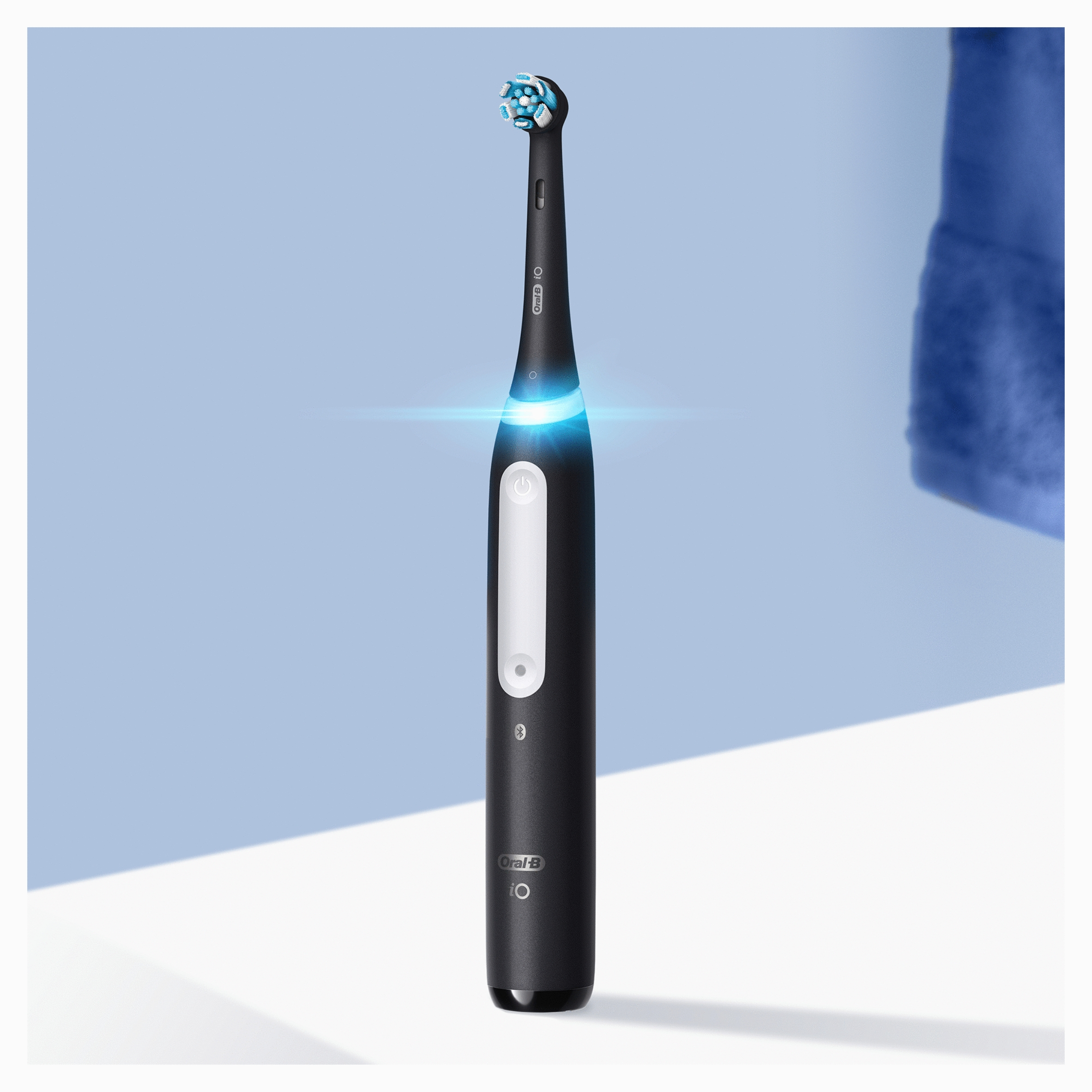 Schwarze elektrische Zahnbürste mit blauer Beleuchtung, weißen Knöpfen und blauem Hintergrund.
