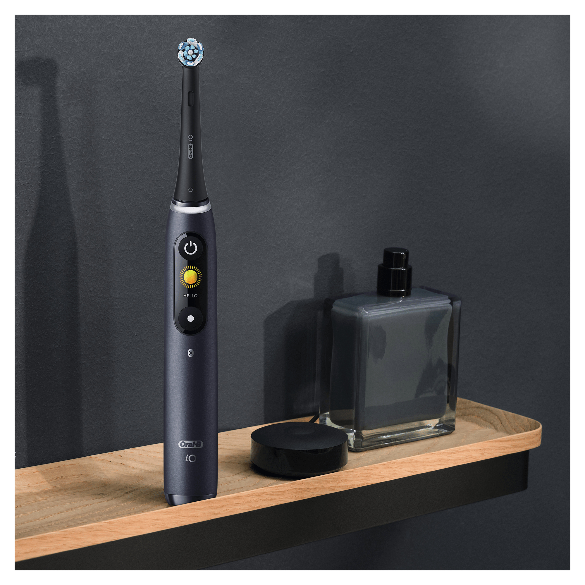 Cepillo de dientes eléctrico en estante de madera. Cepillo azul oscuro, base de carga y fondo gris oscuro.