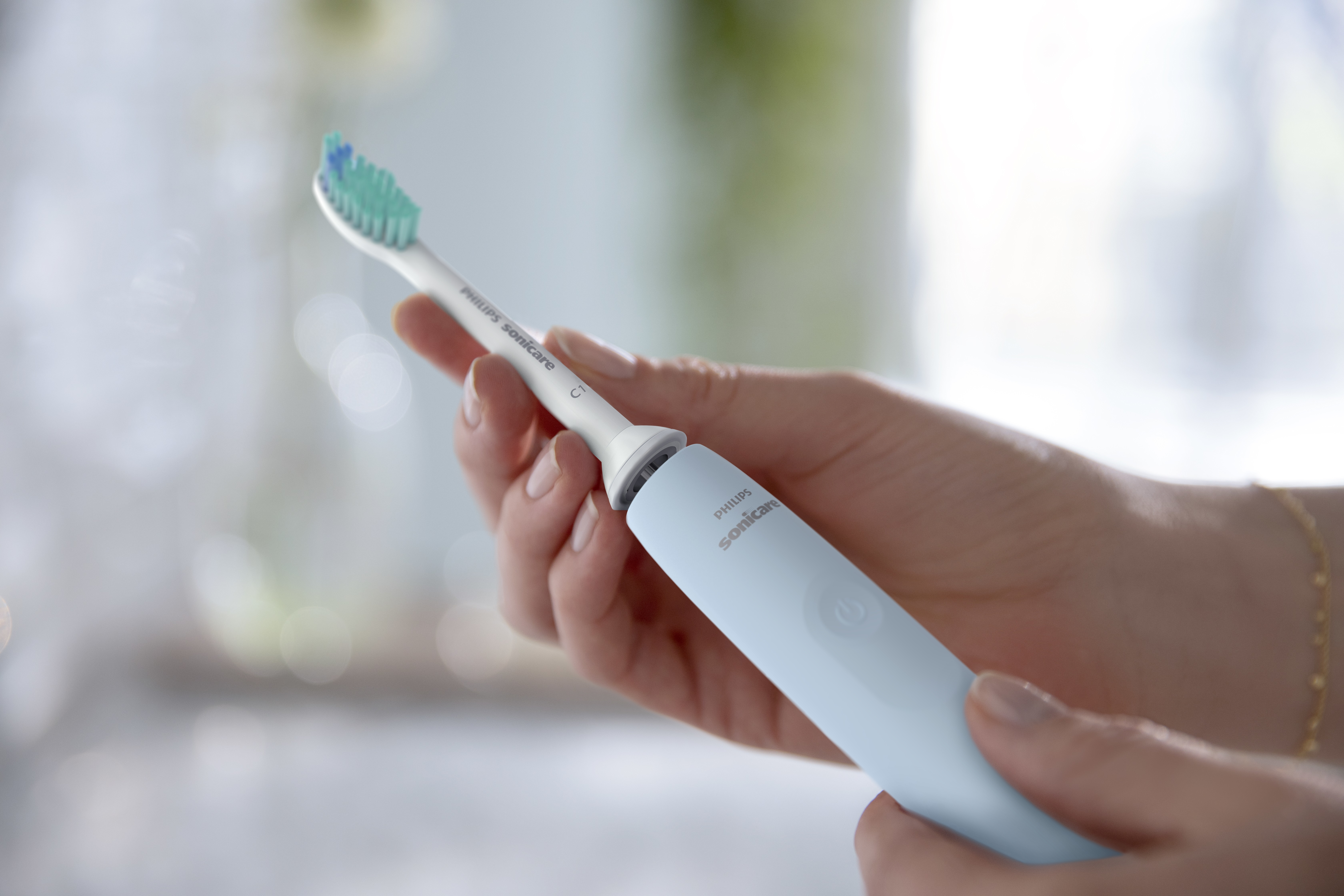 Osoba trzymająca szczoteczkę Philips Sonicare, zbliżenie na główkę szczoteczki.