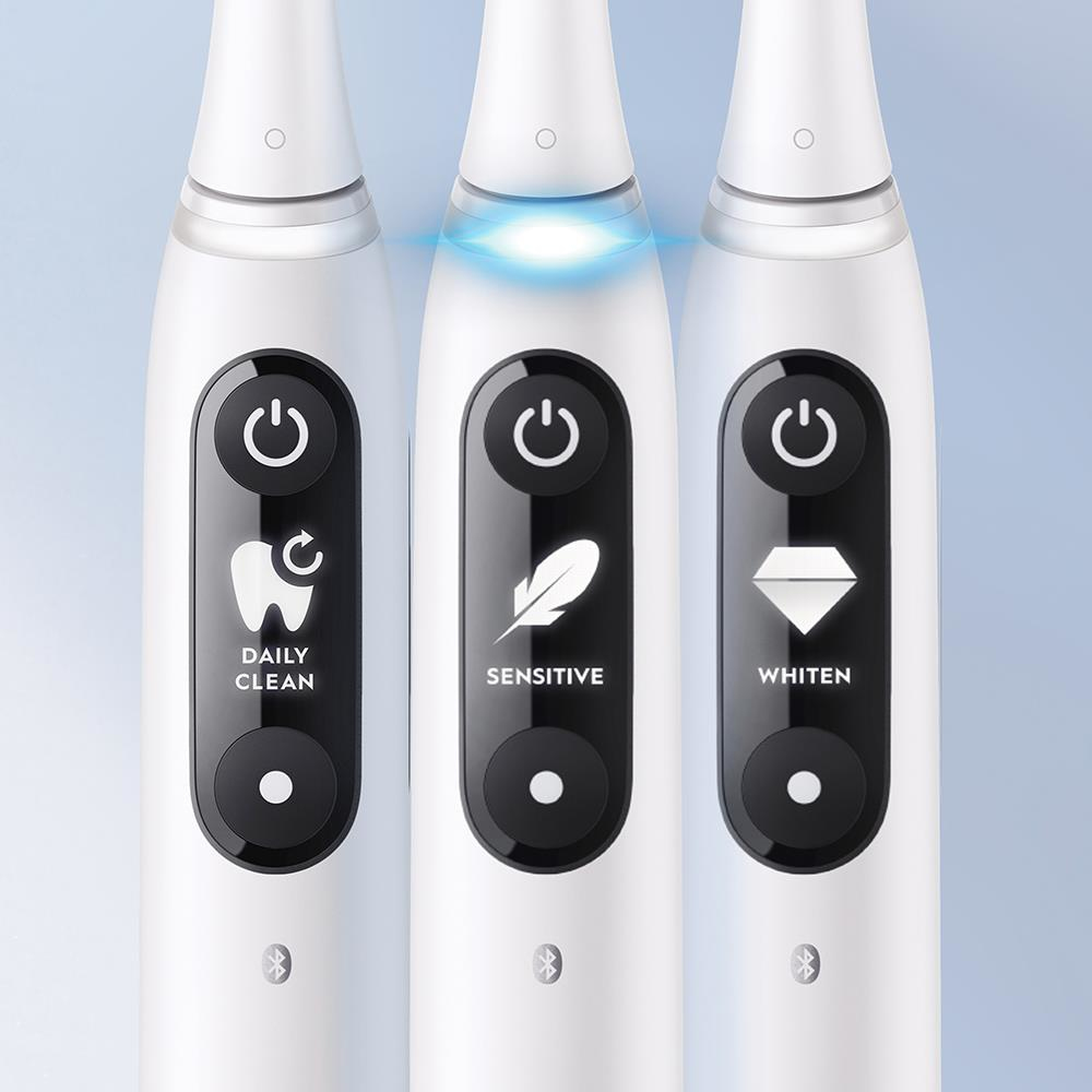 Tres cepillos de dientes eléctricos con diferentes modos de limpieza indicados en el botón.