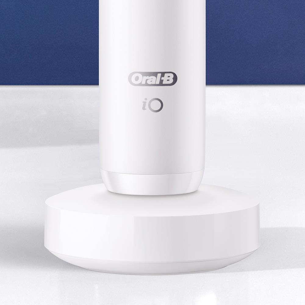Una base de carga blanca con el logotipo de Oral-B iO sobre un fondo azul y blanco.