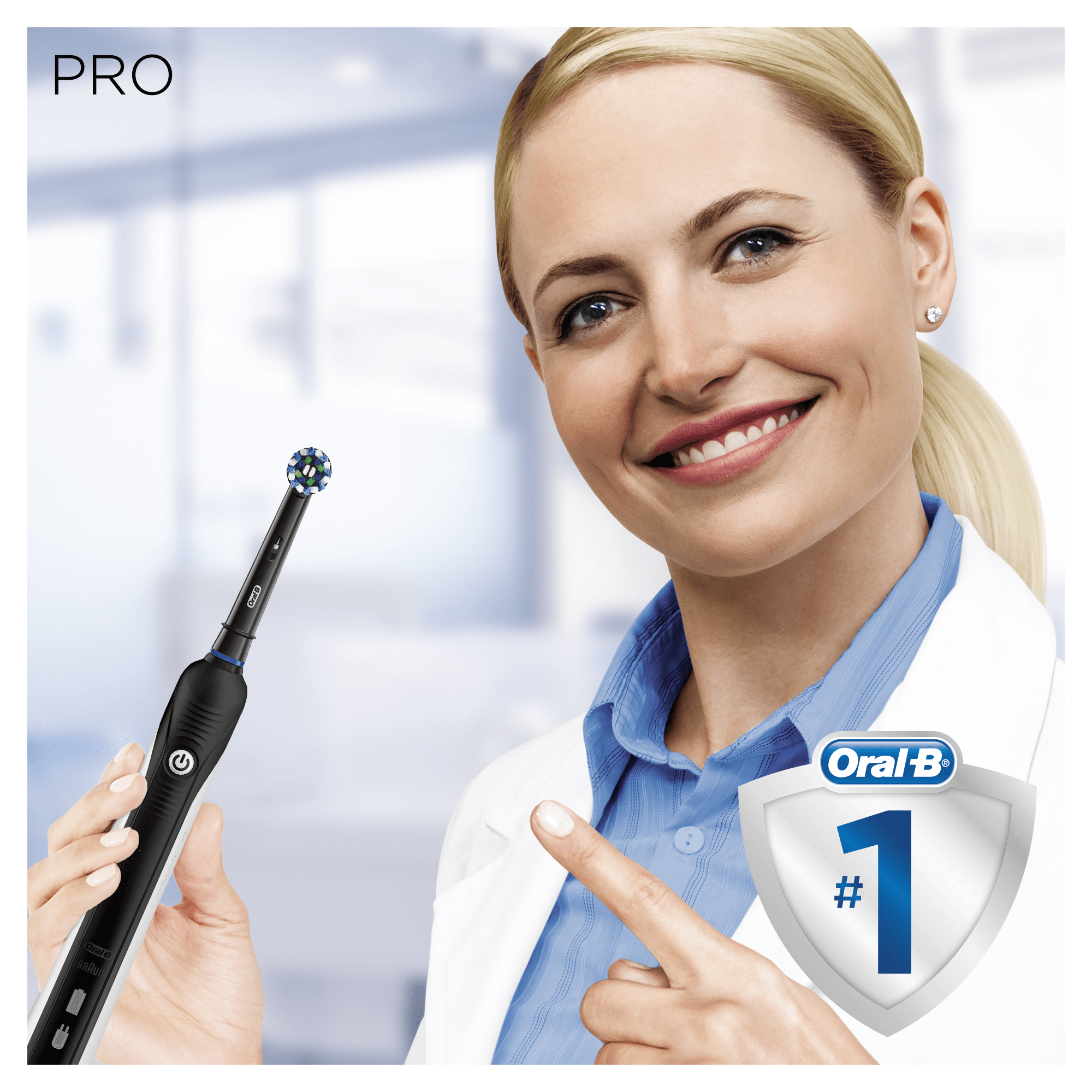 Lächelnde Frau, zeigt auf eine elektrische Zahnbürste. Oral-B Logo und ein Schild mit der Nummer 1 rechts.