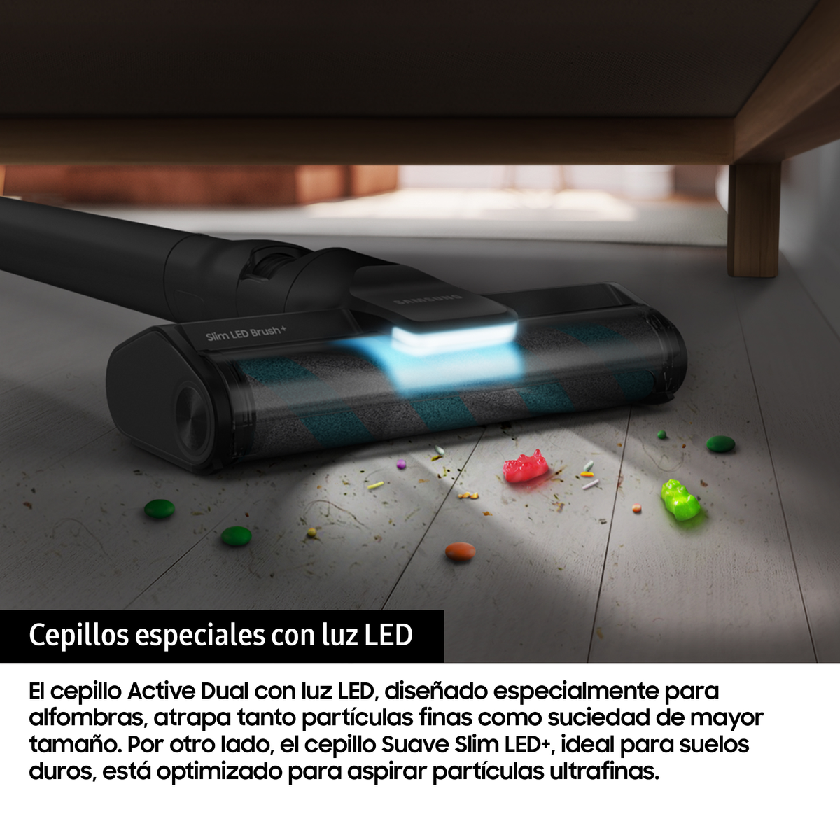Un cabezal negro de aspiradora en un suelo de madera con residuos. El cabezal tiene una luz LED azul.