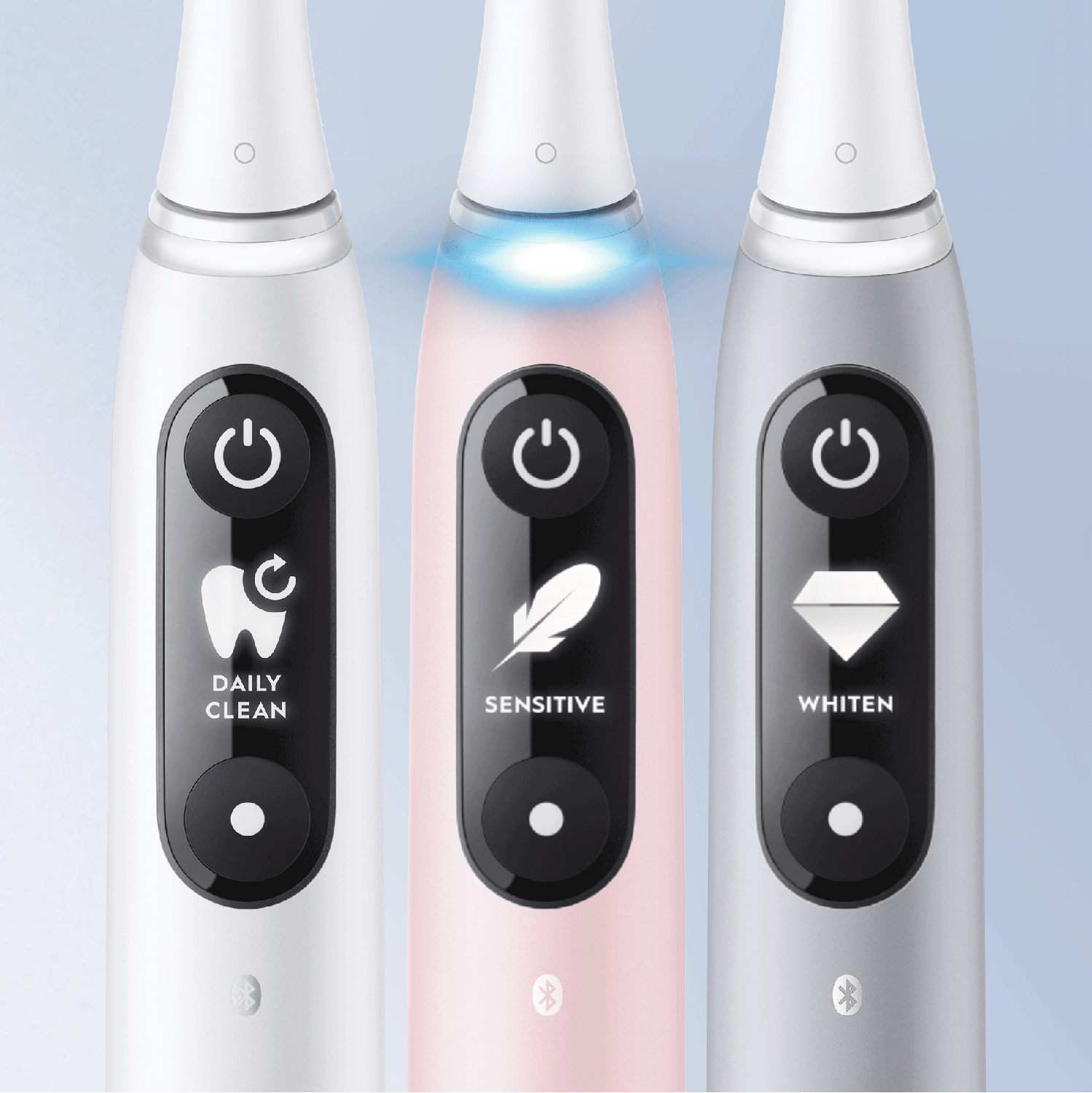 Drie witte, roze en zilveren elektrische tandenborstels. Elk heeft een andere functie: Dagelijks reinigen, Gevoelig, Witter maken.