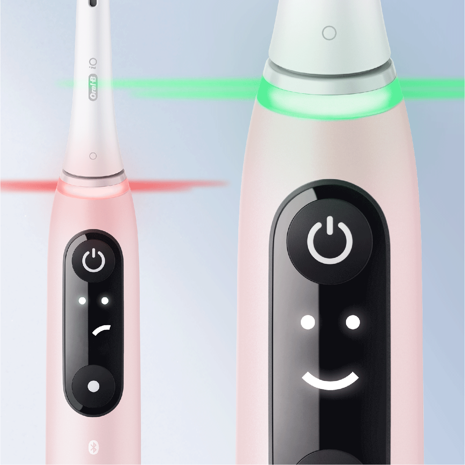 Twee roze tandenborstels. De linker toont rood licht, de rechter groen licht.