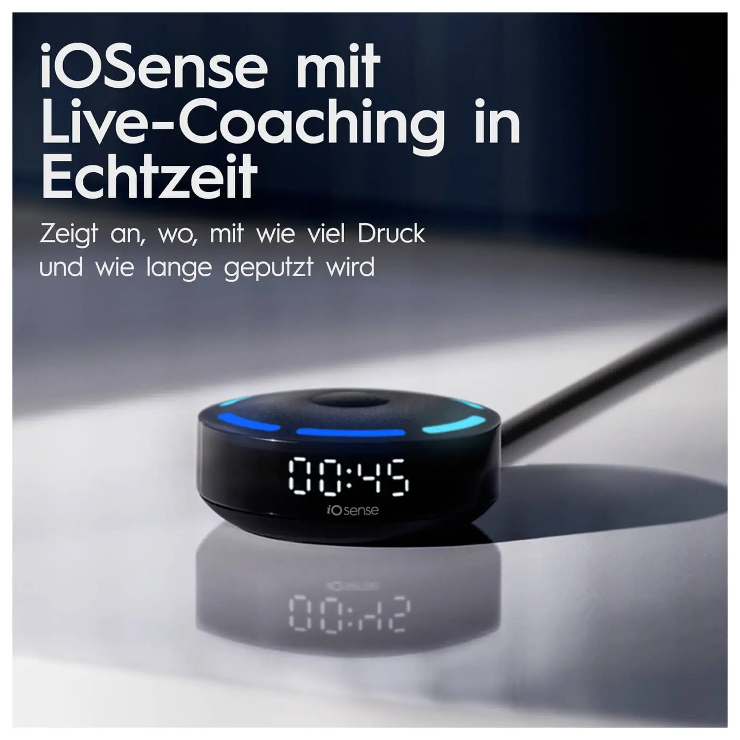 Schwarzes rundes Gerät mit Anzeige 00:45, umgeben von blauen Lichtern, auf reflektierender Oberfläche.