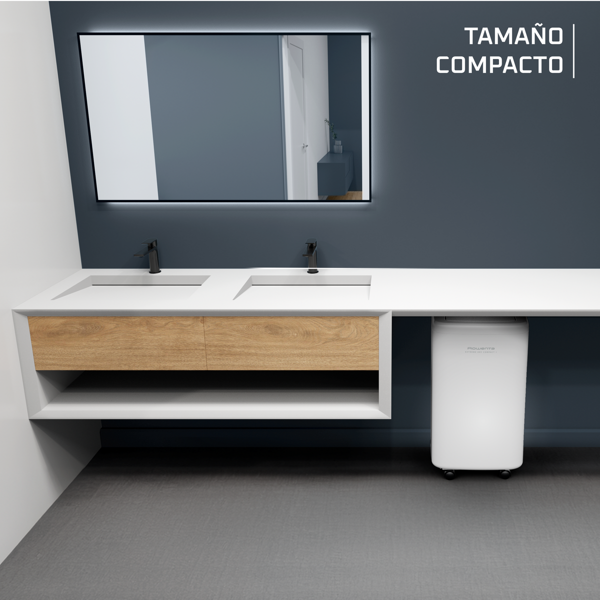 Scena bagno con un grande specchio sopra un mobile doppio lavabo. Testo: 'TAMANO COMPACTO'.