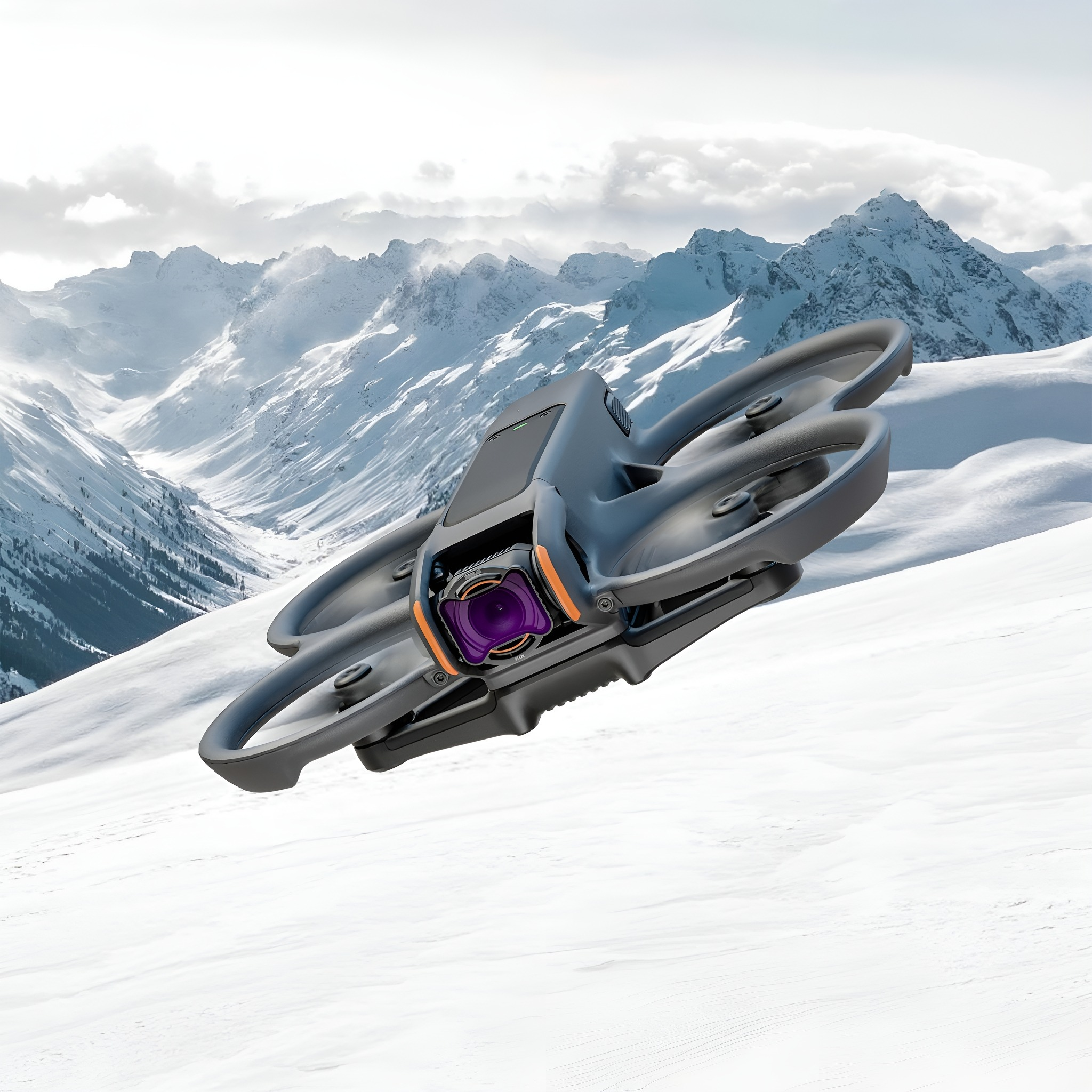Eine graue Drohne fliegt über einer verschneiten Berglandschaft. Orange Kameralinse ist vorne sichtbar.