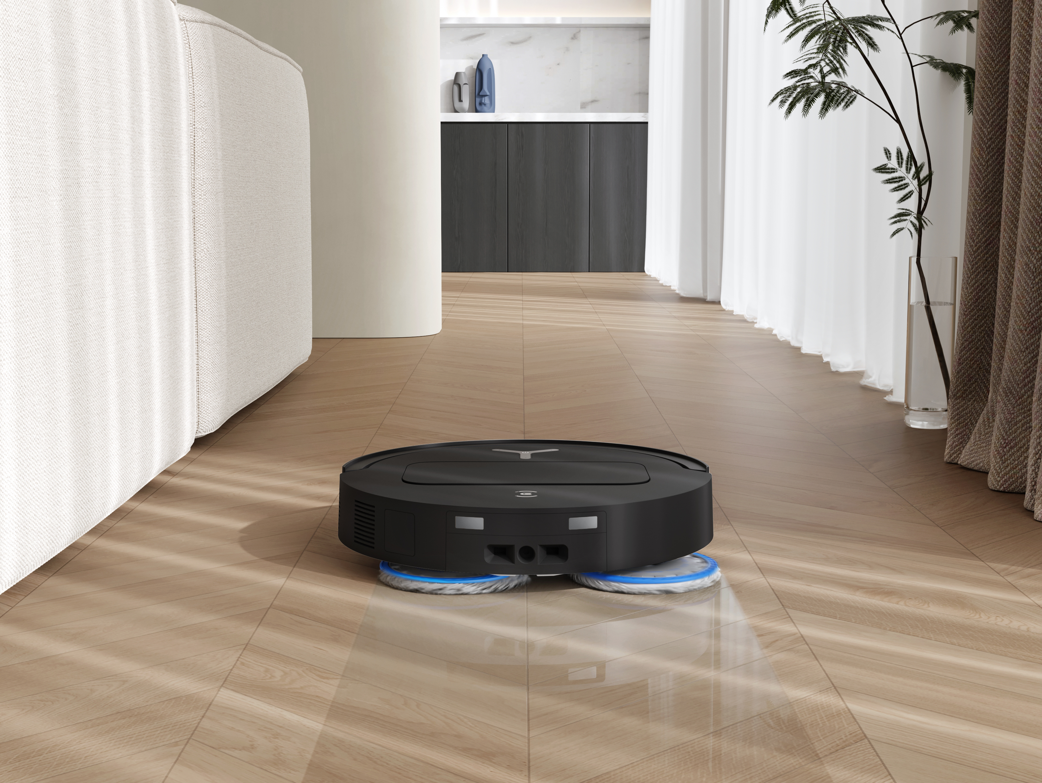 Ein schwarzer, kreisförmiger Roboter-Staubsauger auf einem Holzboden. Ein weißes Sofa und eine Pflanze im Hintergrund.