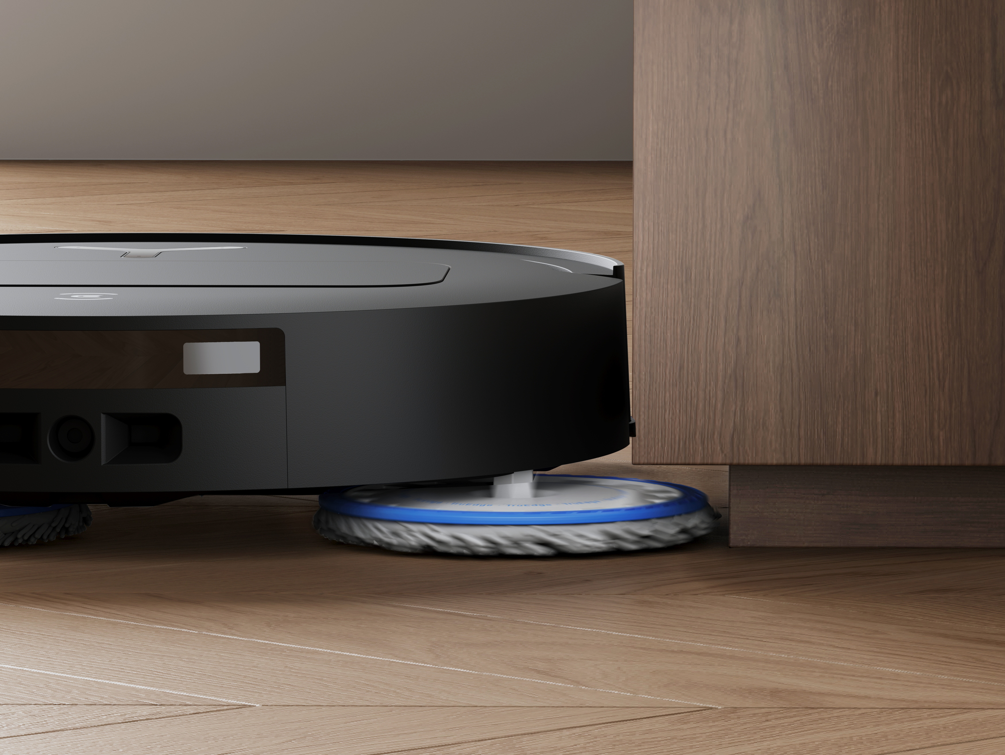 Ein Roboter-Staubsauger nähert sich einem Holzschrank. Der Staubsauger befindet sich auf einem Holzboden.
