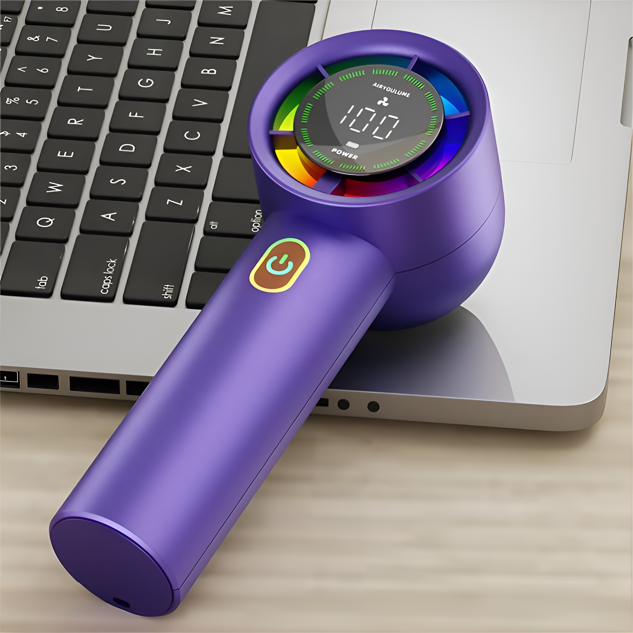 Lila Handventilator auf Laptop-Tastatur mit digitaler Anzeige.