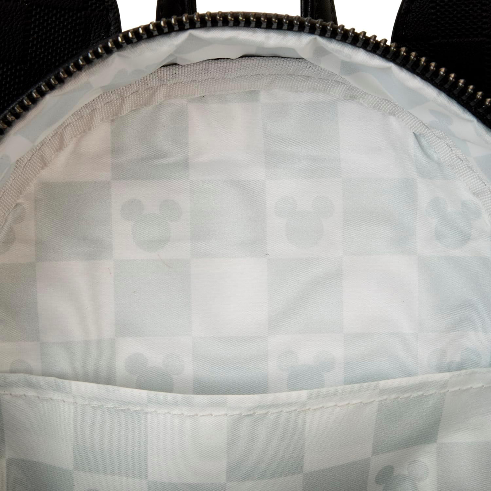 Innenseite eines schwarzen Rucksacks mit weißem Schachbrettmuster und Mickey Mouse Silhouetten.
