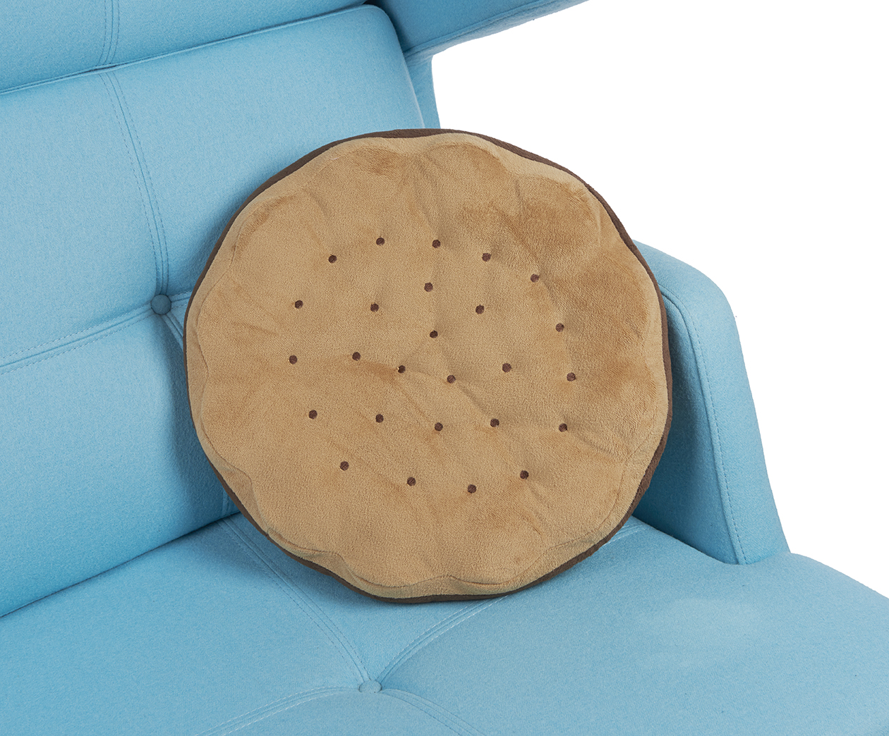 Rundes Kissen in Form eines Kekses auf einer blauen Couch.