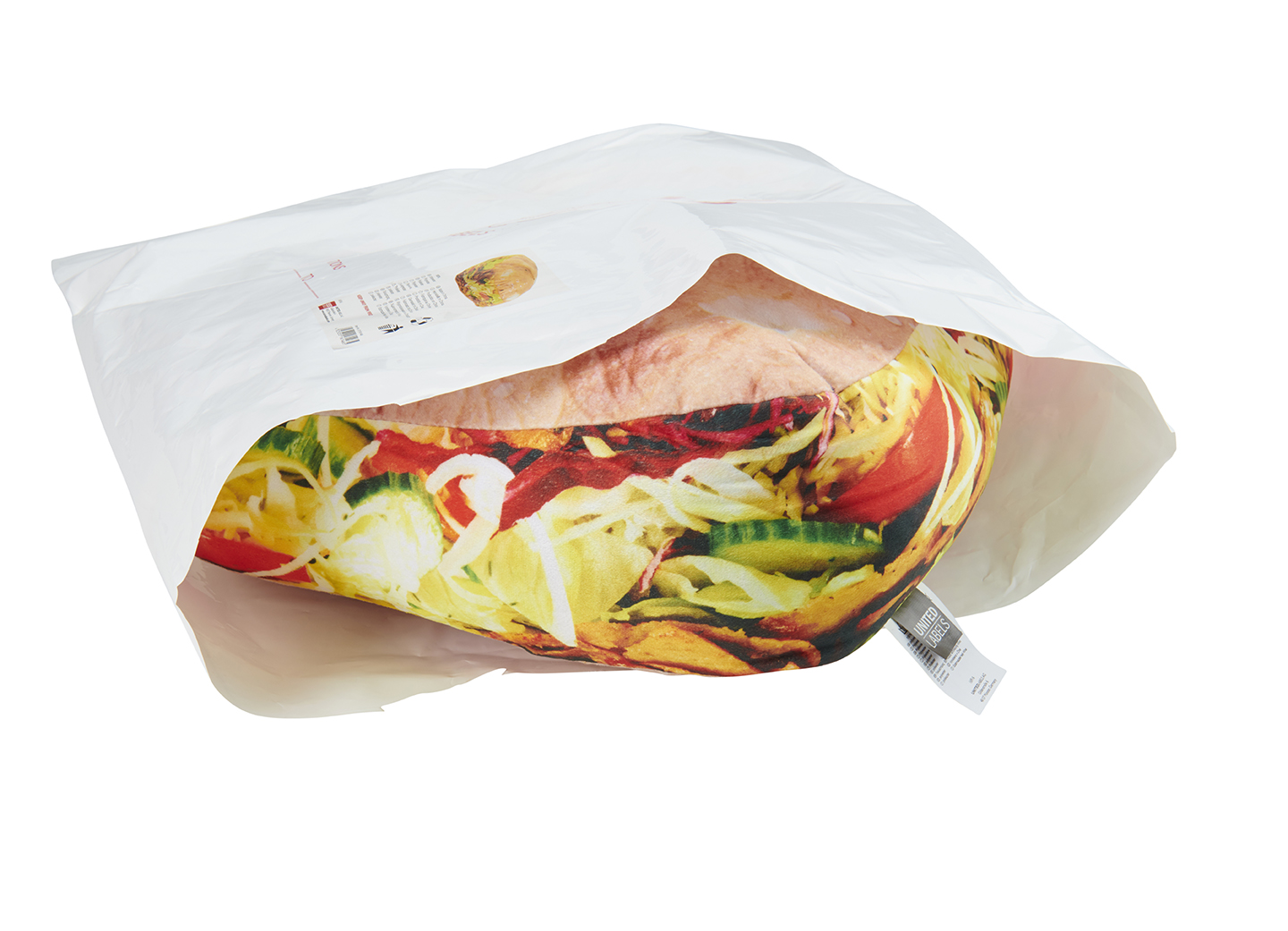Eine weiße Papiertüte, die sich öffnet und ein kissenförmiges, farbenfrohes Salat zeigt.