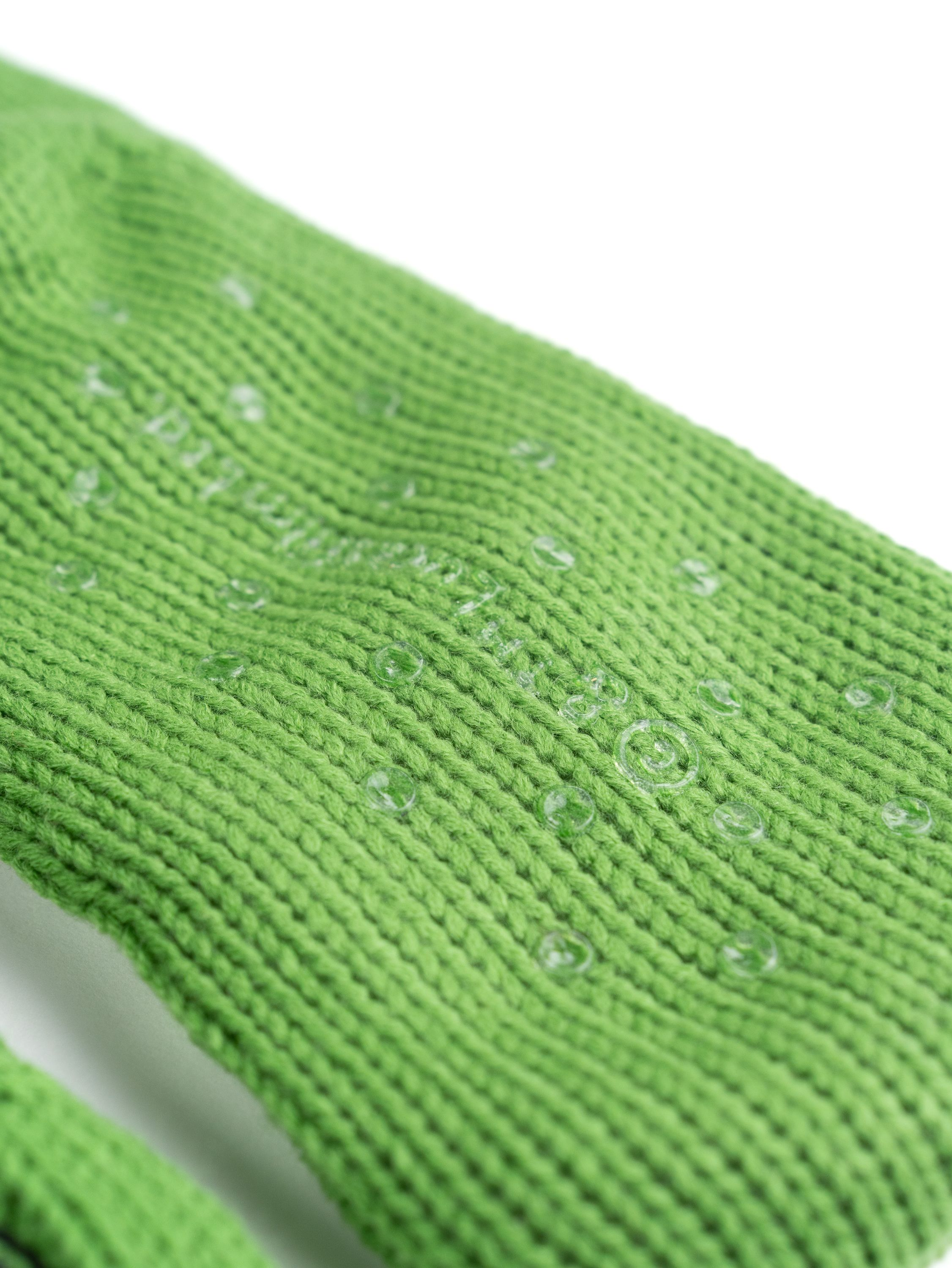 Grüner Strickstrumpf mit transparenten, kreisförmigen Griffen auf weißem Hintergrund.