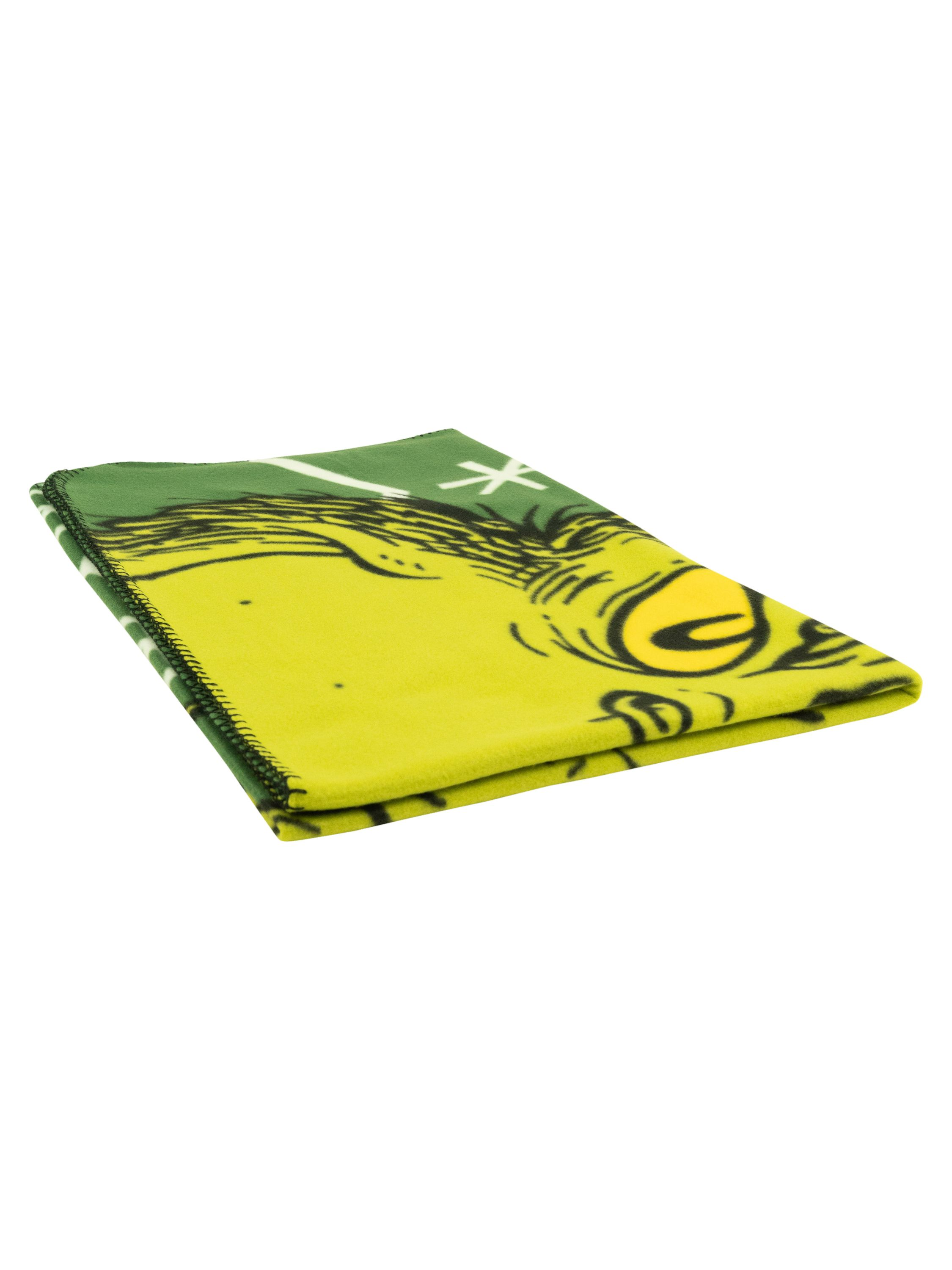 Eine gefaltete grüne und gelbe Decke mit einer Grinch-Illustration. Die Decke liegt auf einer weißen Oberfläche.