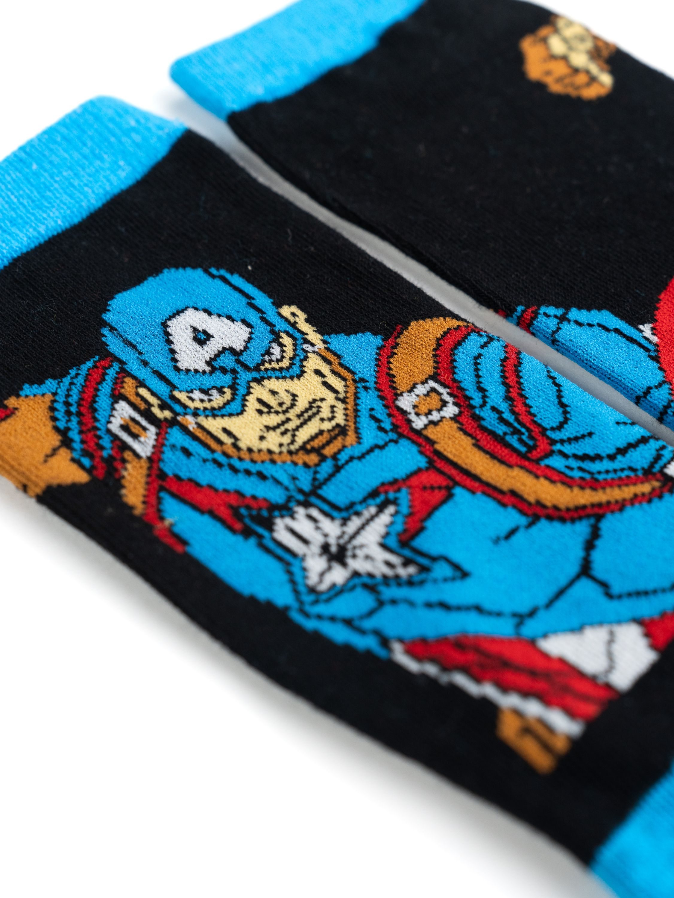 Paar Captain America Socken. Blaues und schwarzes Design mit Captain Americas Gesicht und Schild.