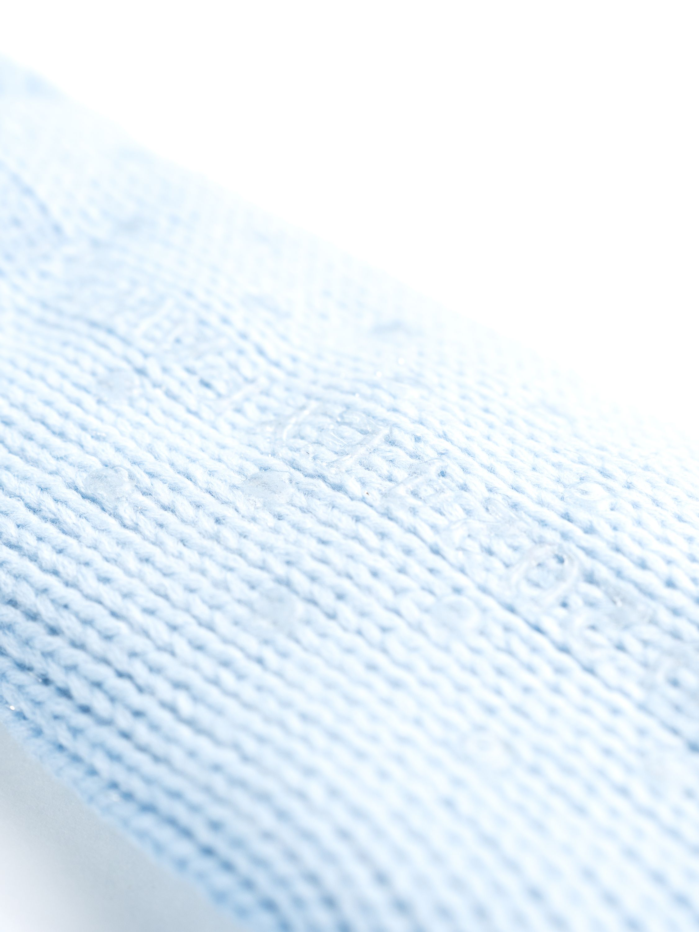 Hellblaues Strickgewebe, Nahaufnahme, mit subtiler Textur und Musterung.