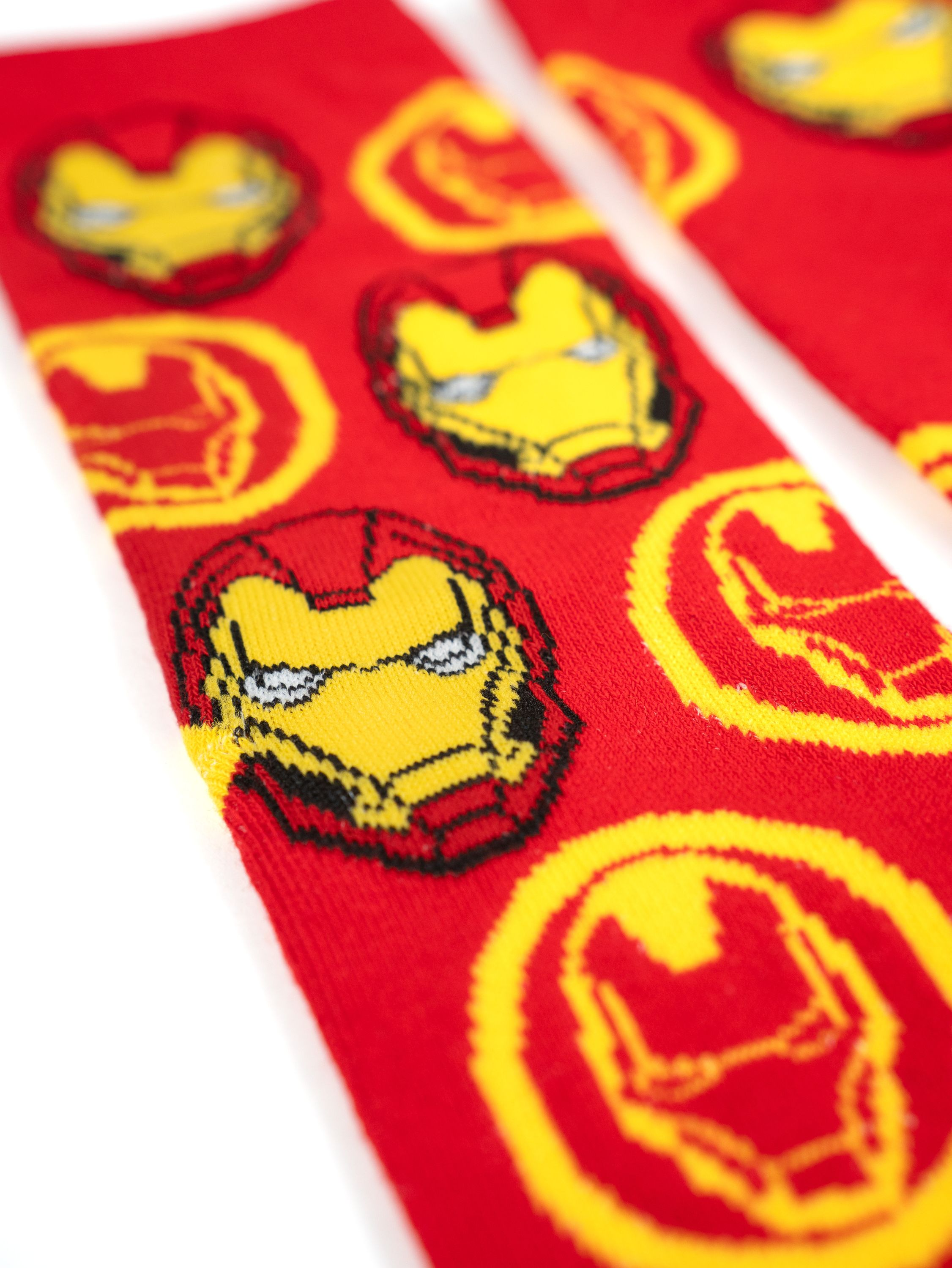 Rote Socken mit Iron Man-Gesichtsmustern. Mehrere Iron Man-Gesichter in gelben Kreisen sichtbar.