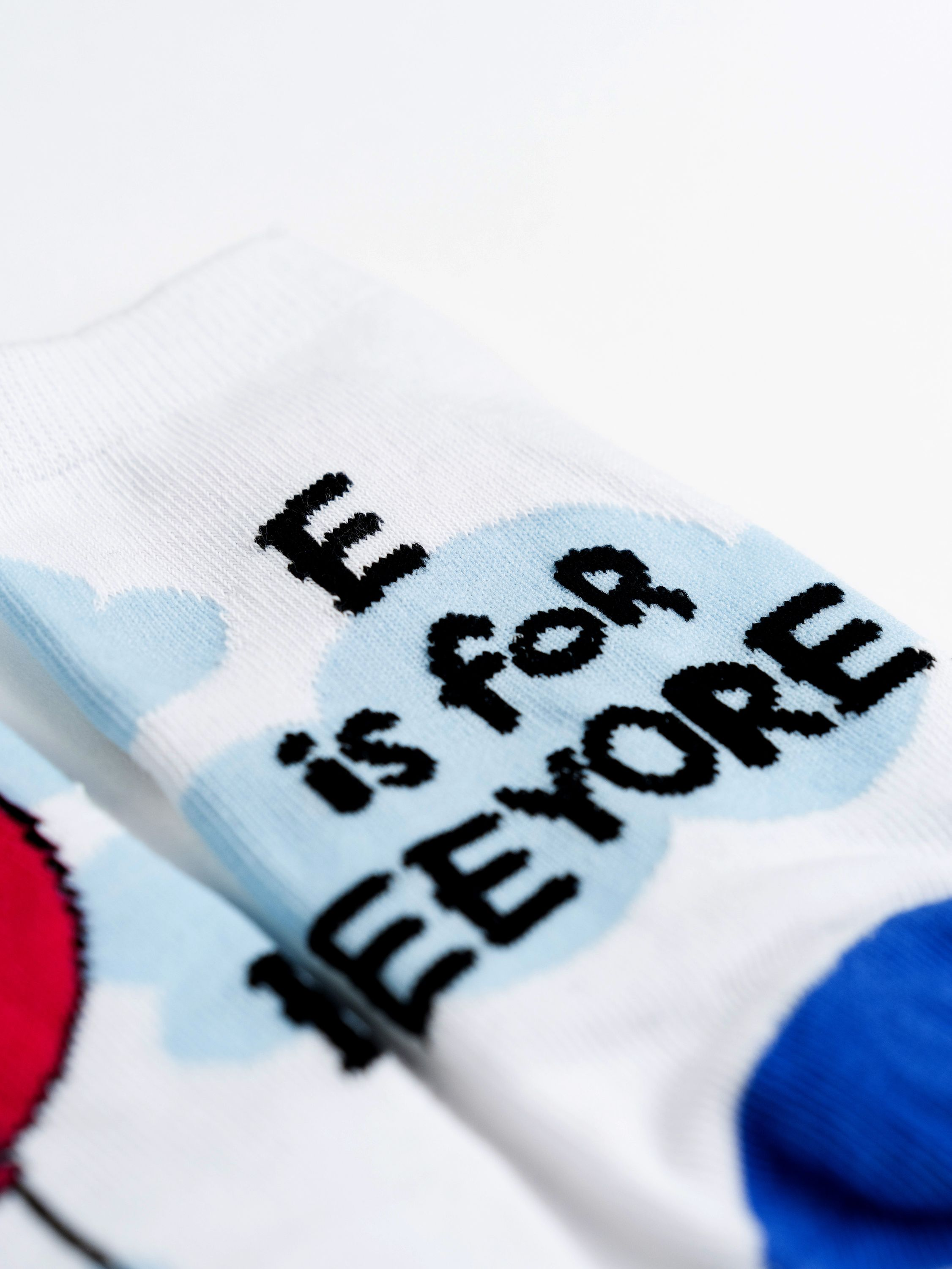 Eine weiße Socke mit dem Satz "E ist für Eeyore" und einer Cartoon-Wolke.