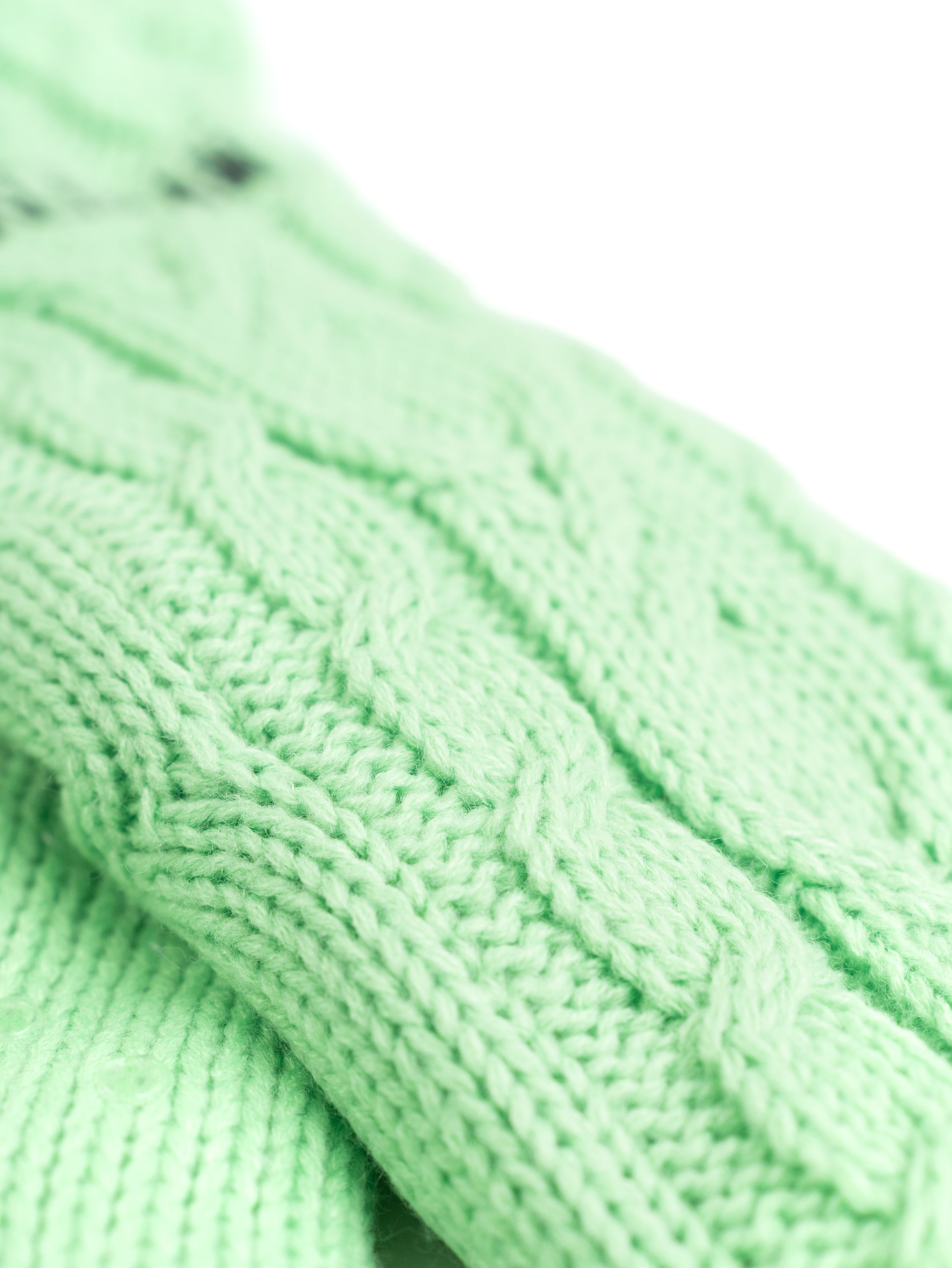 Nahaufnahme eines hellgrünen Strickstoffs. Das Muster ist ein Zopfmuster.