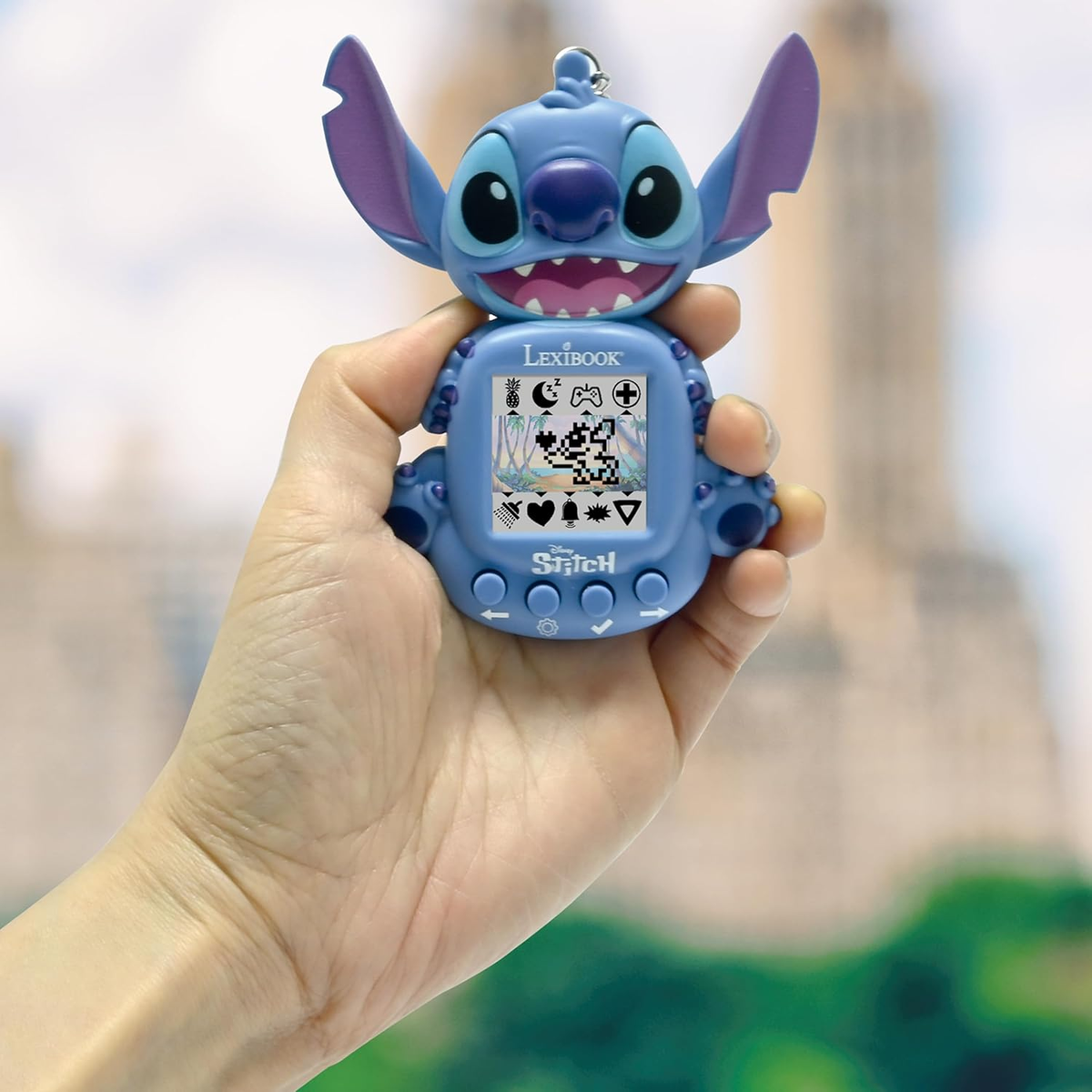 Una mano tiene un giocattolo elettronico blu a forma di Stitch con un piccolo schermo.