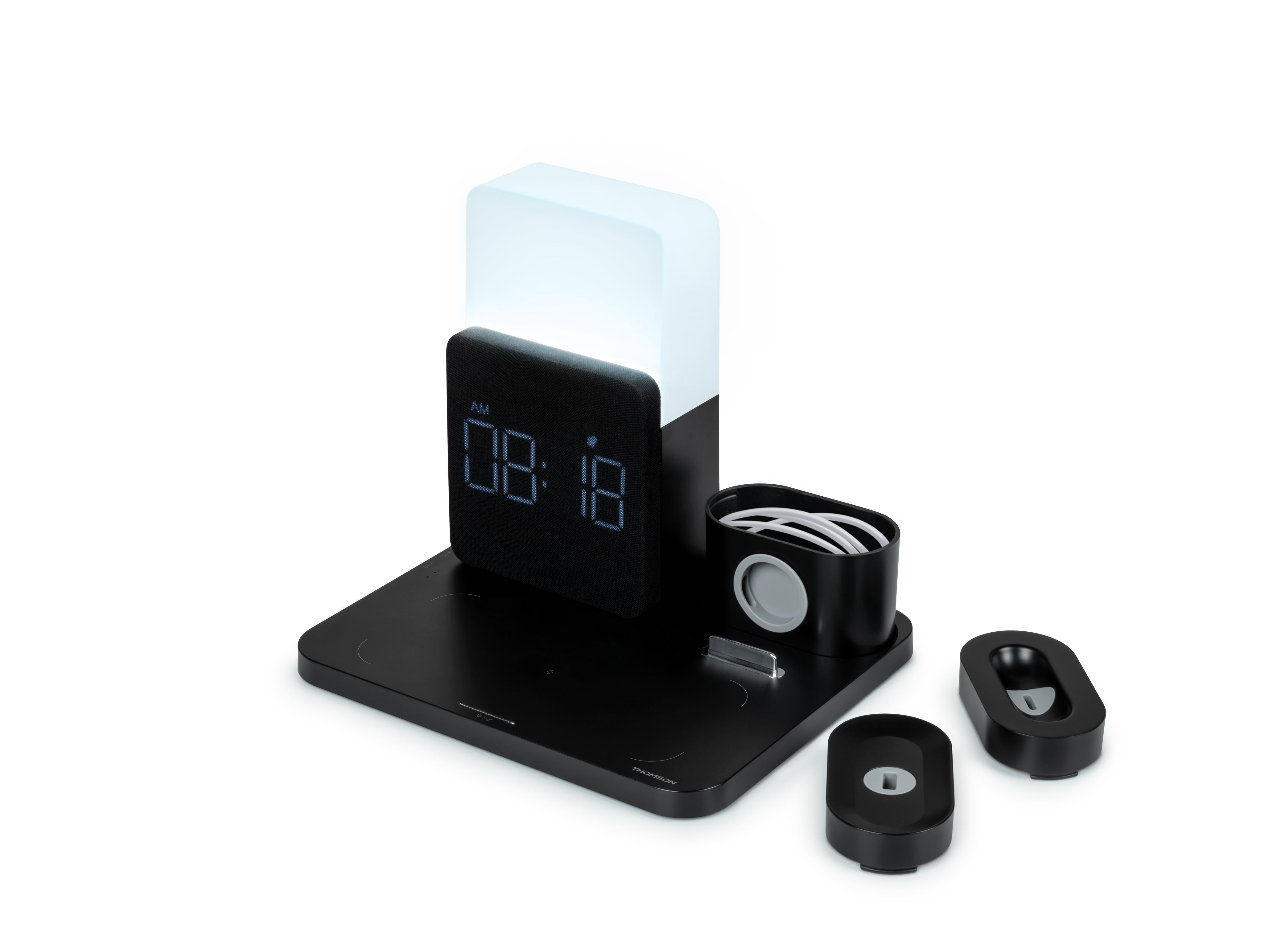 Czarna stacja ładująca z zegarem, obszarami ładowania telefonu i zegarka. Białe tło.