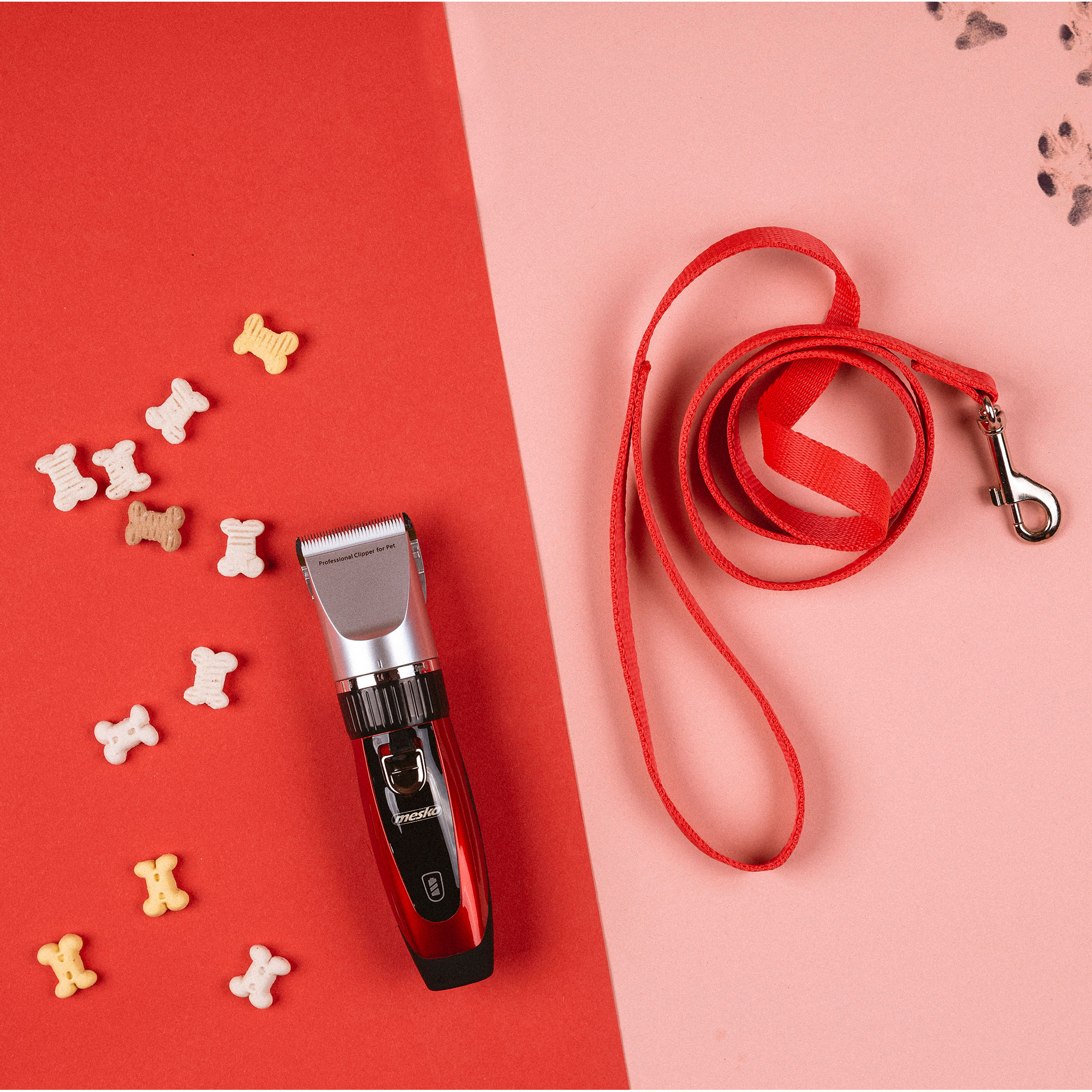 Kit de aseo para perros rojo con correa roja y golosinas en forma de hueso sobre fondo rosa y rojo.