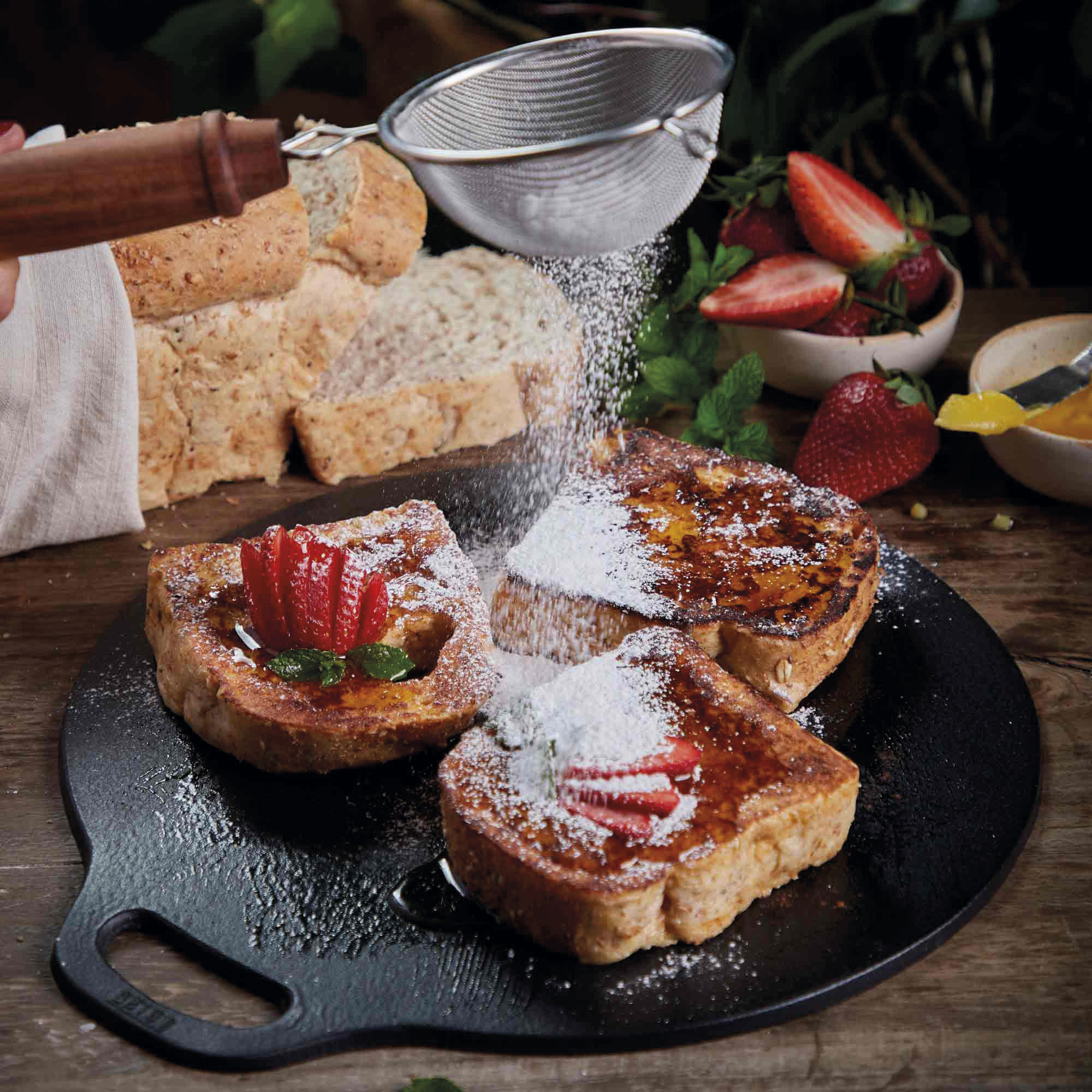 Arme Ritter mit Puderzucker, Erdbeeren und Ahornsirup.