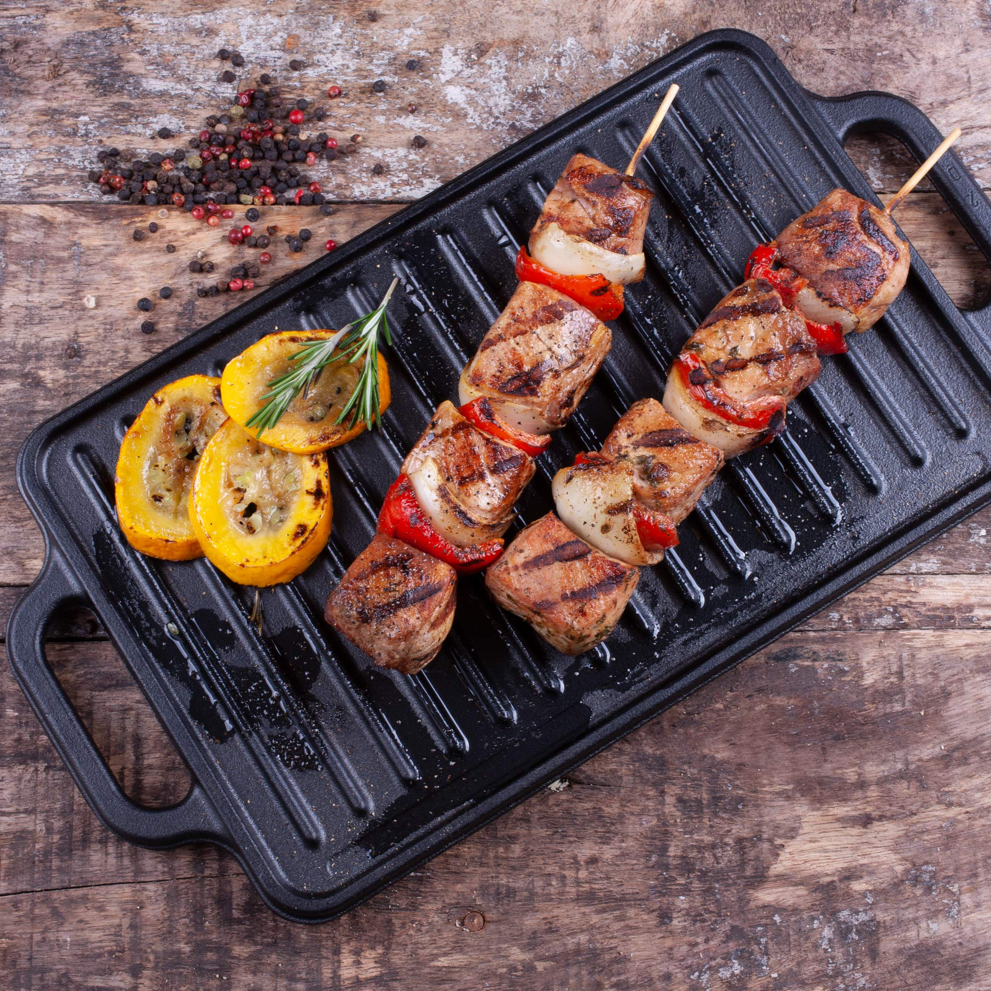 Spieße mit gegrilltem Fleisch und Paprika, gegrillte Zucchini und Pfefferkörner.