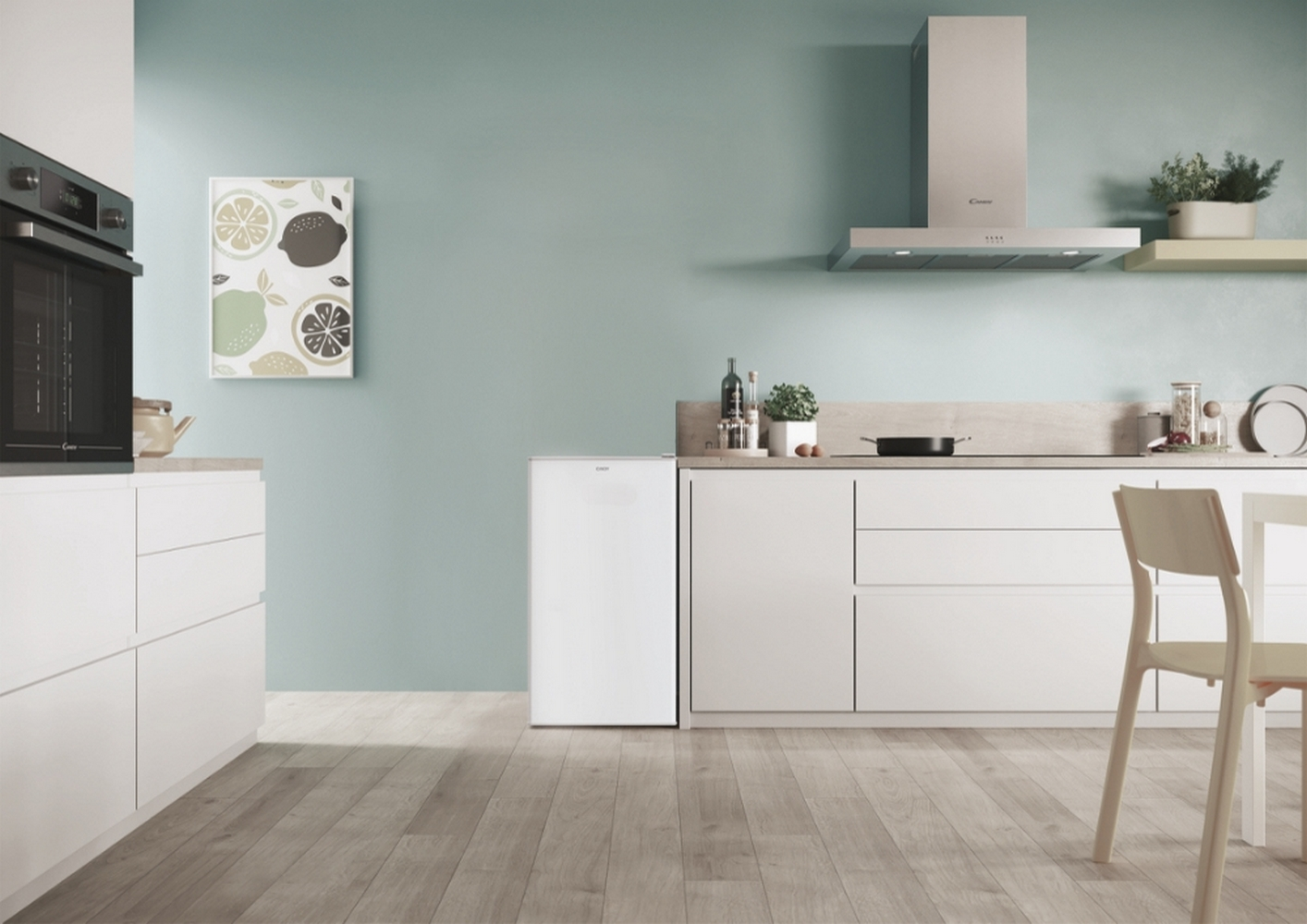 Una scena di cucina moderna con mobili bianchi, un frigorifero e un'opera d'arte di agrumi incorniciata.