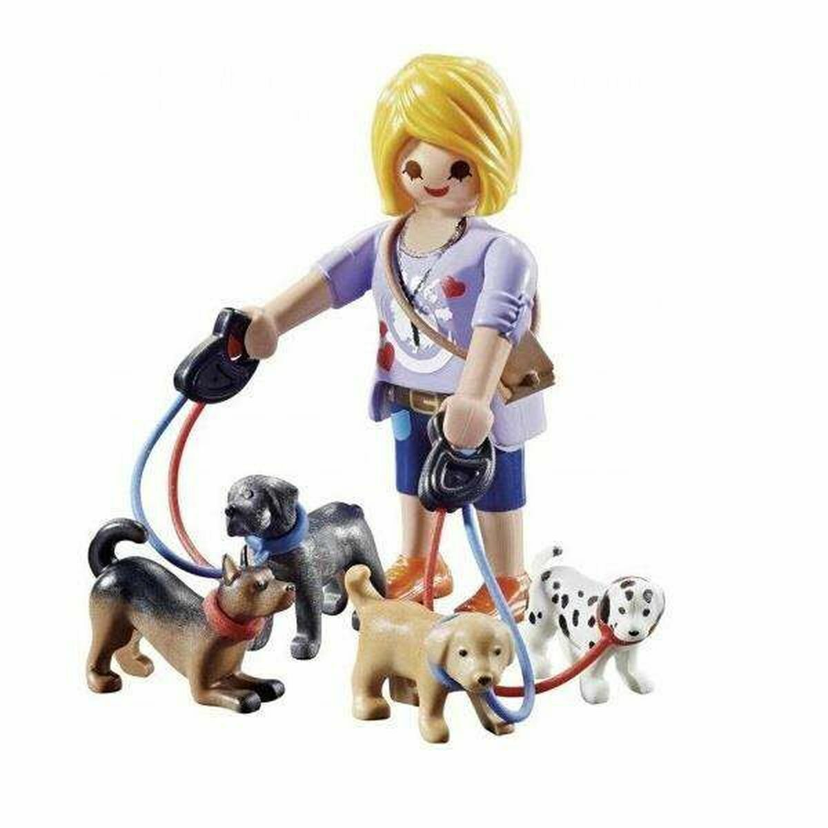 Eine Playmobil-Figur mit vier Hundespielzeugen an Leinen. Die Hunde umfassen einen Dalmatiner und drei andere.