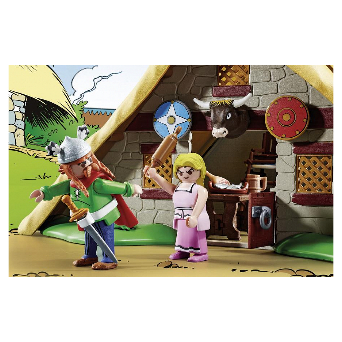 Dos figuras de Playmobil en una escena de aldea. Un hombre con espada y una mujer con un rodillo.
