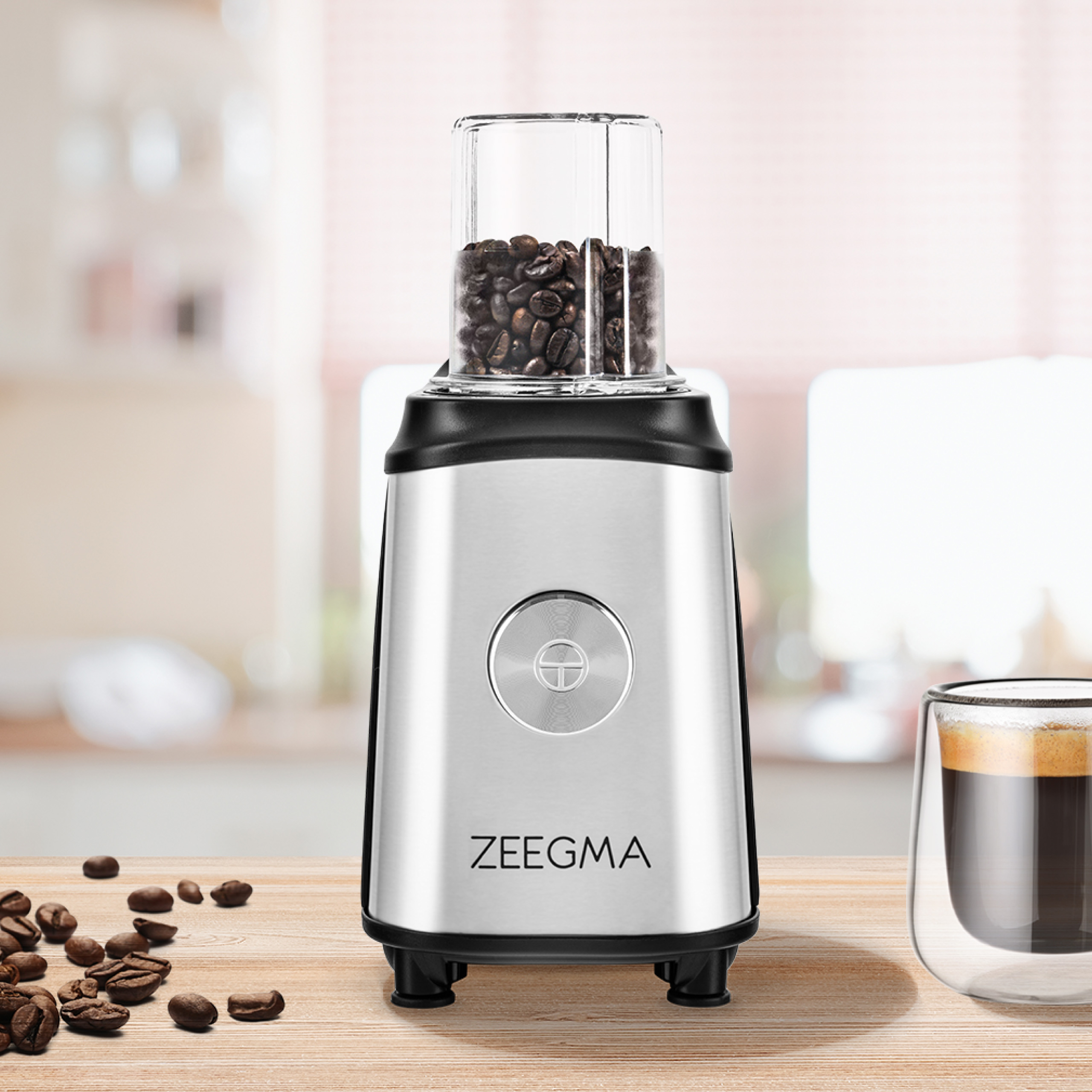 Srebrno-czarny młynek do kawy z ziarnami kawy w szklanym pojemniku.