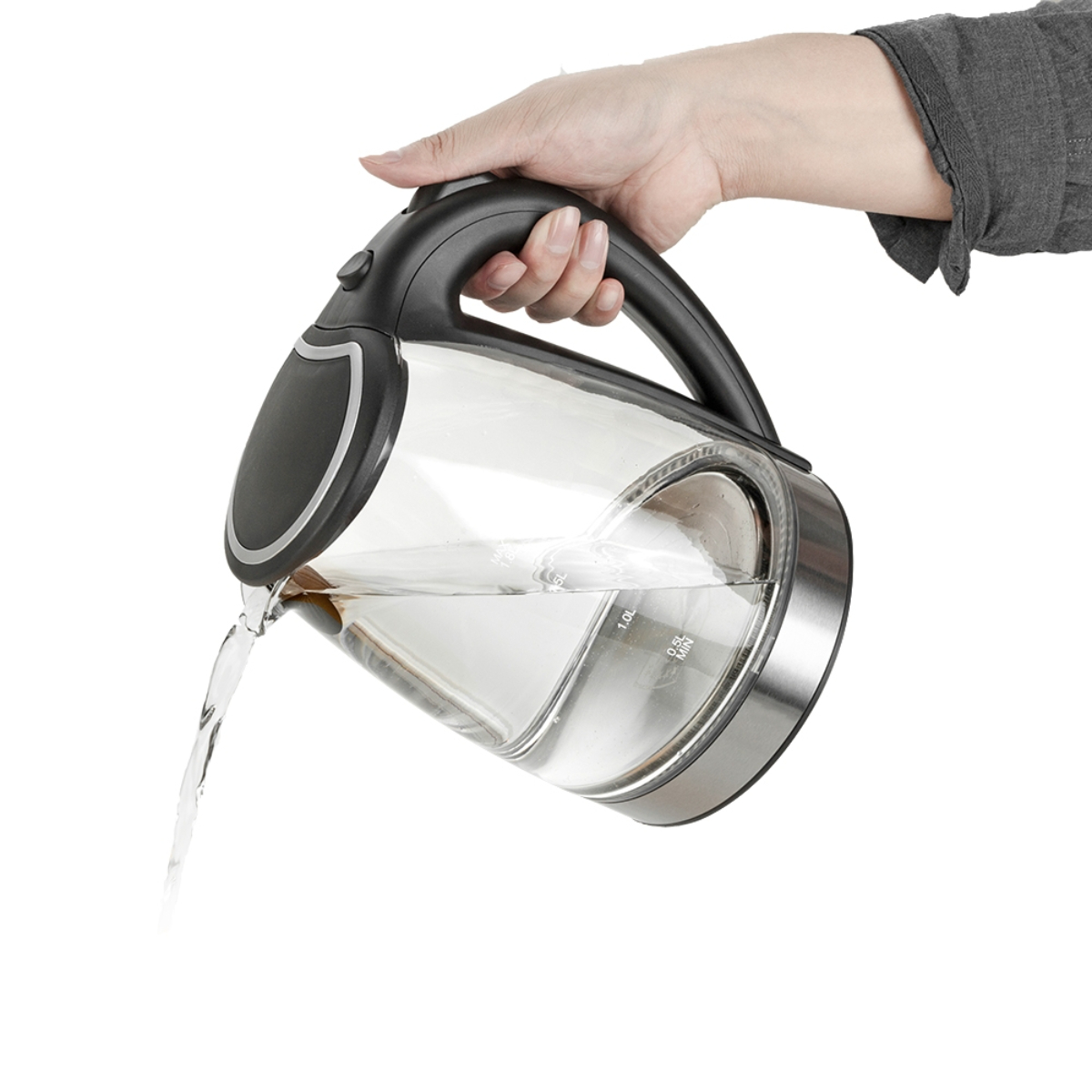 Eine Hand gießt Wasser aus einem transparenten elektrischen Glaskessel. Der Hintergrund ist weiß.