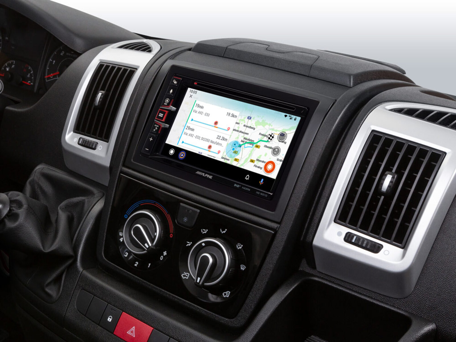 Armaturenbrett eines Autos mit Navigationsbildschirm, Lüftungsschlitzen und Klimaanlage.