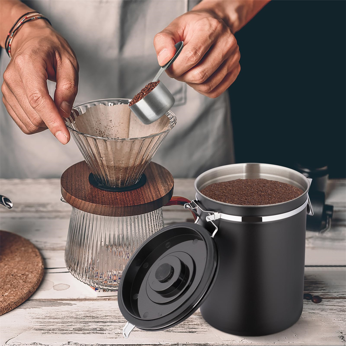 Person gießt Kaffeepulver in einen Filter, Kaffeebehälter rechts.