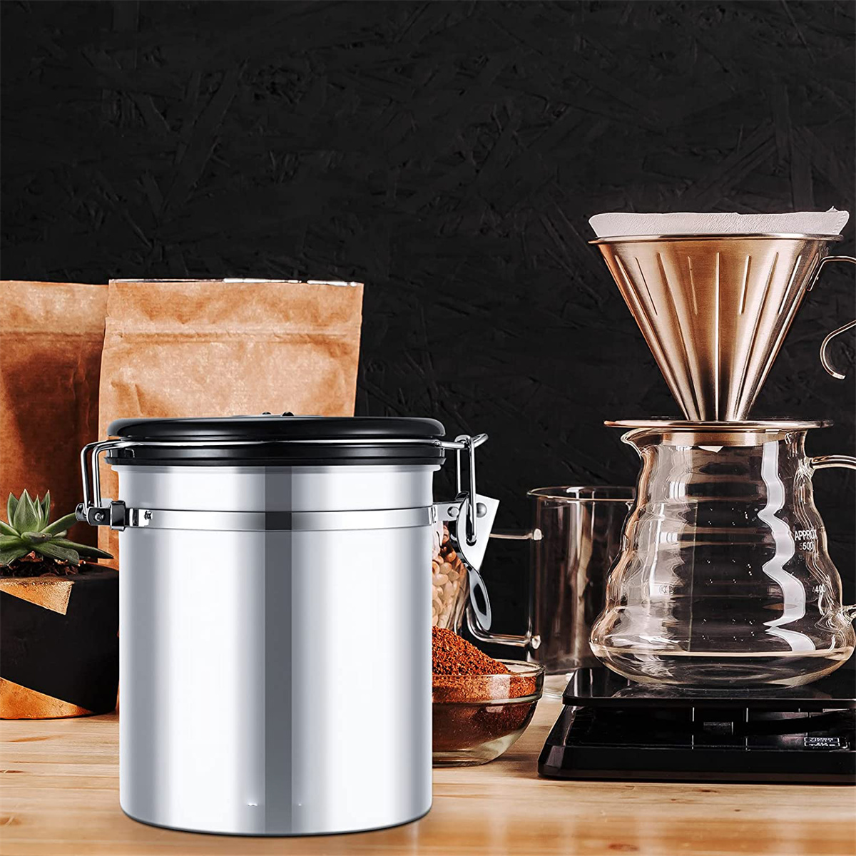 Silberner Kaffeebehälter neben Kaffeezubereitungsmaterialien. Kaffeebohnen, eine Waage sind sichtbar.