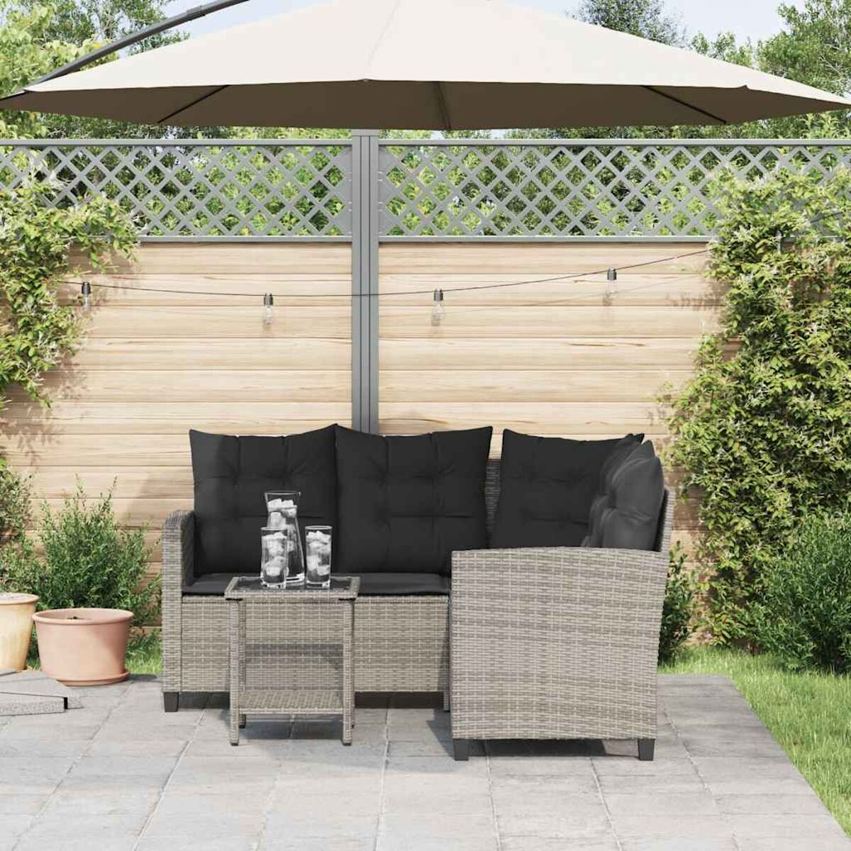 Outdoor-Terrassenset mit Sofa, Sessel, Tisch und Sonnenschirm.