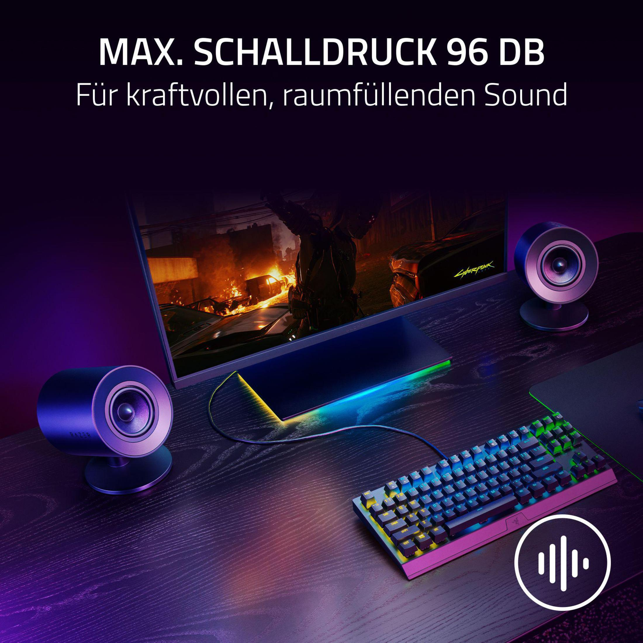 Gaming setup met een monitor, speakers, toetsenbord en tekst: MAX. SCHALLDRUCK 96 DB.